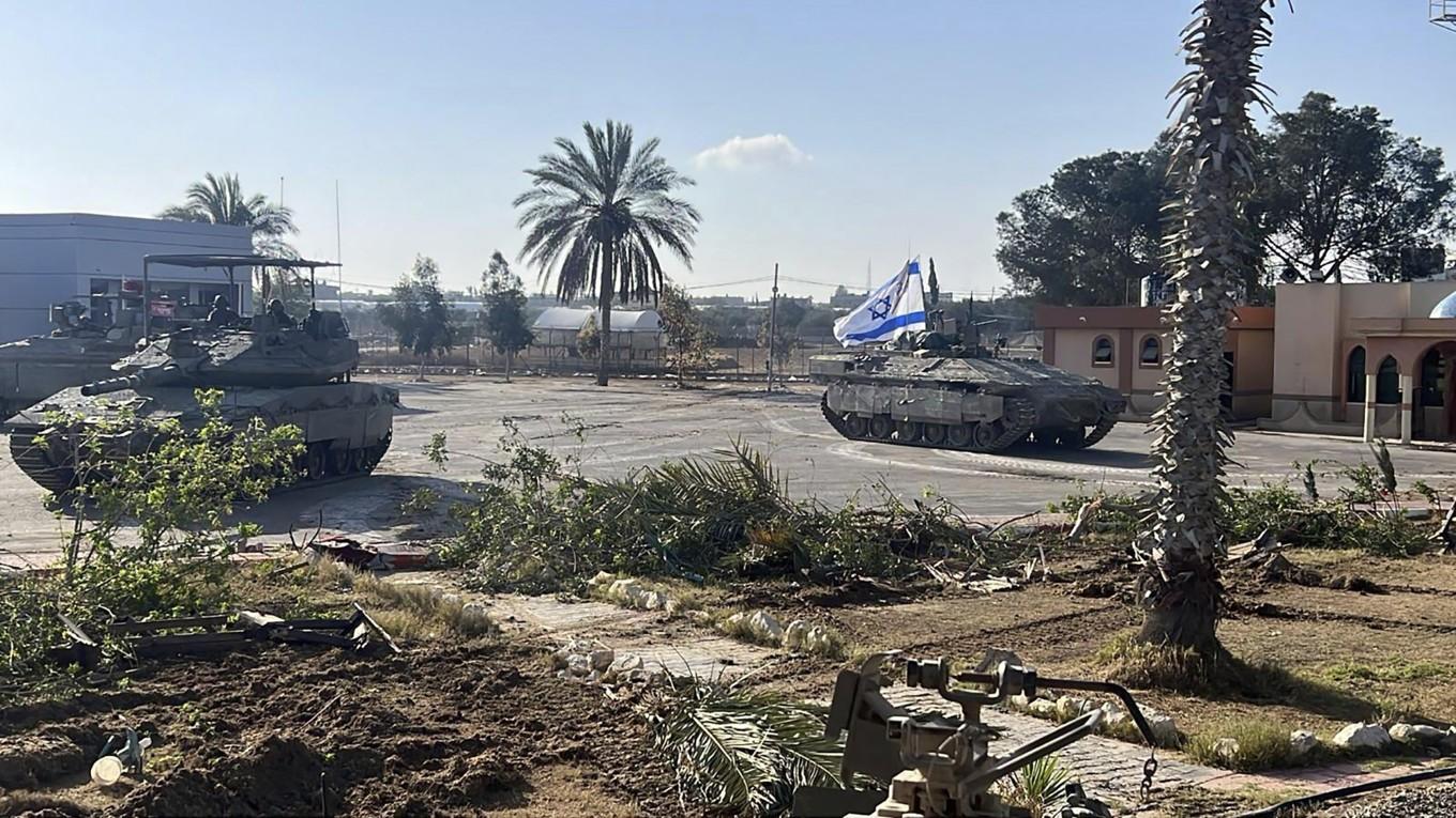 På denna bild, som tillhandahållits av Israels militär syns en stridsvagn med en israelisk flagga som kör in till Gaza-sidan vid gränsövergången Rafah på tisdagen. Foto: Israel Defense Forces via AP/TT