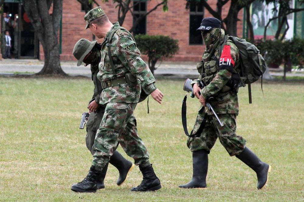 
En colombiansk soldat eskorterar ELN-rebeller som kapitulerat på en militärbas i staden Cali 2013.  Foto: Juan Bautista Diaz/AP/TT-arkivbild                                            