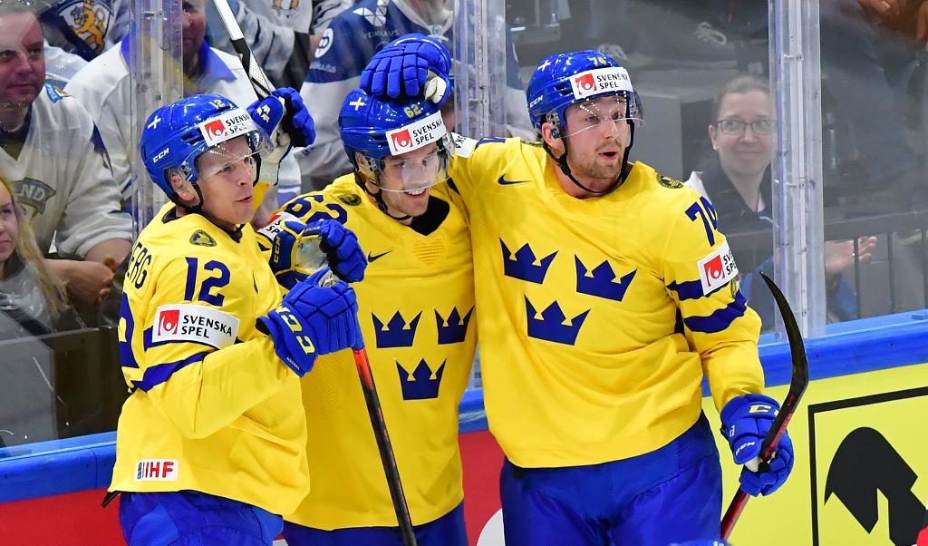 Max Friberg, till vänster, jublar tillsammans med Joel Kellman, i mitten, och Rasmus Asplund efter 2–0-målet i segermatchen mot Österrike i VM-premiären. Foto: Jonas Ekströmer/TT