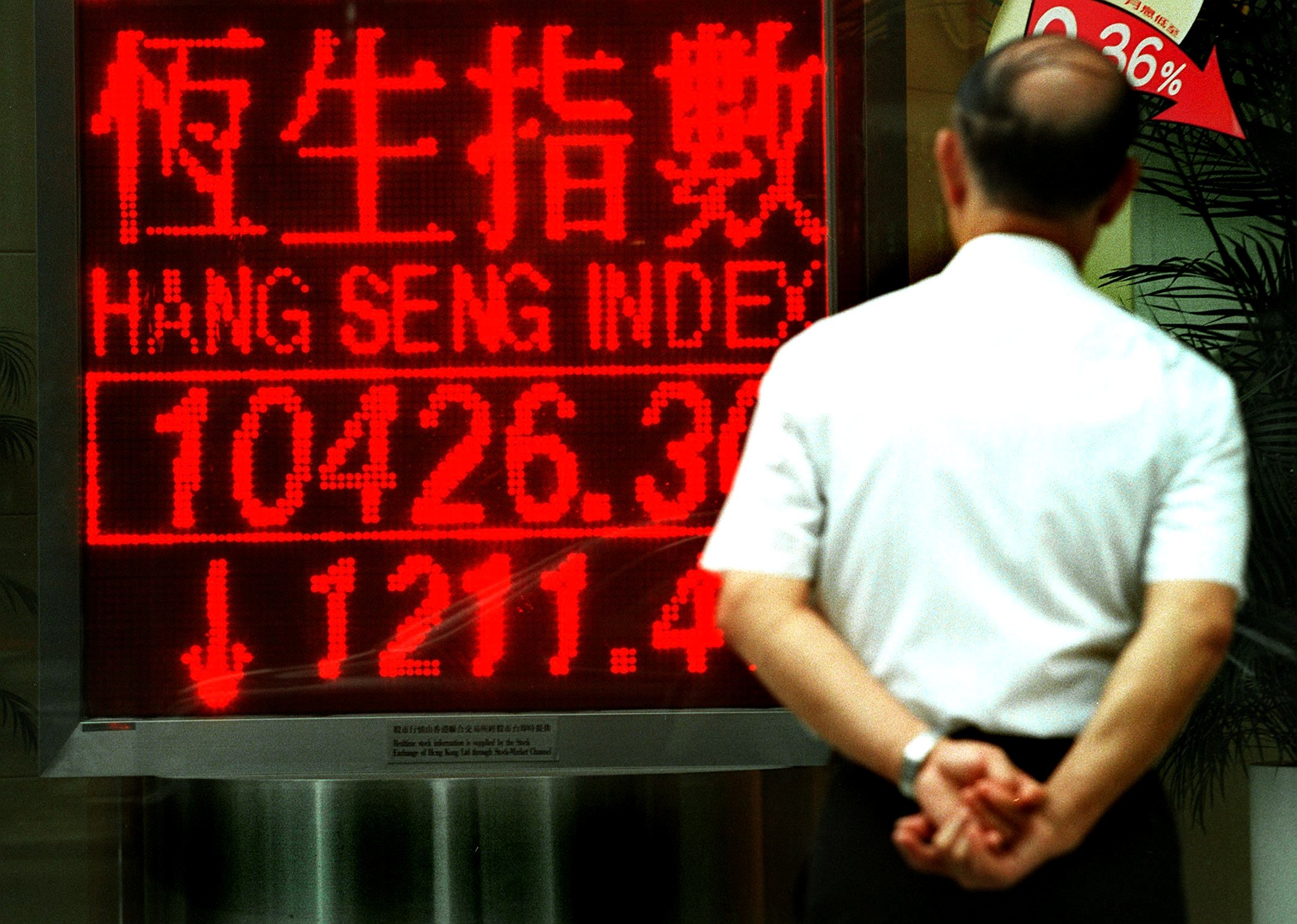 En man i Hongkong tittar på en elektronisk tavla. Foto: Stephen Shaver/AFP via Getty Images