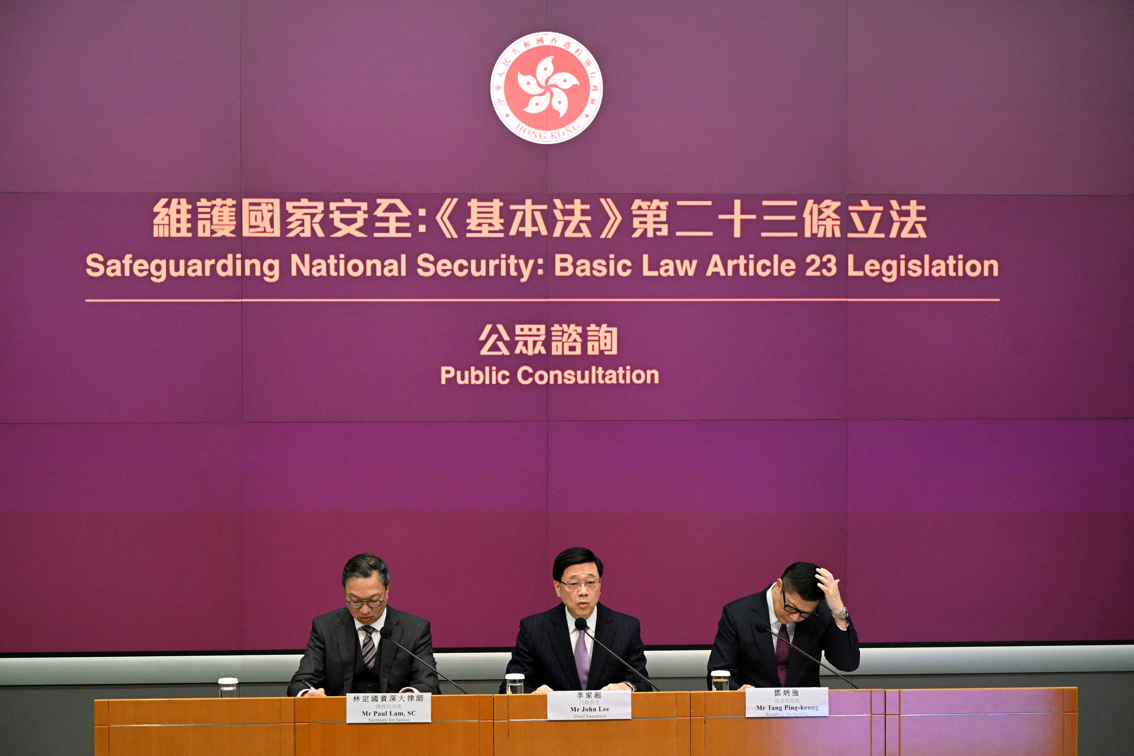 Hongkongs regeringschef John Lee (mitten), justitieminister Paul Lam (vänster) och säkerhetsminister Chris Tang (höger) håller en presskonferens i regeringshögkvarteret i Hongkong den 30 januari 2024. (Foto: Peter Parks/AFP via Getty Images