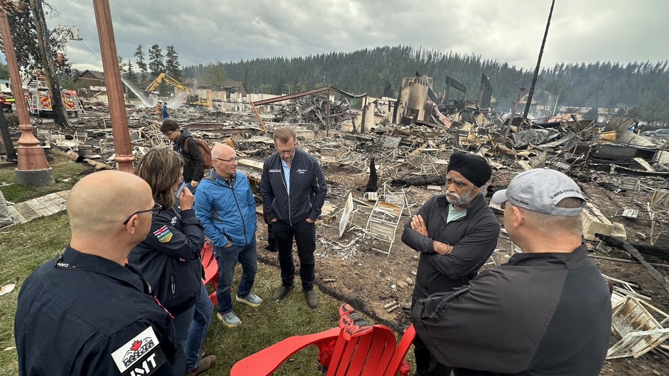 Lokalbefolkning står vid nedbrunna byggnader i Jasper, Kanada, den 26 juli. De omfattande bränderna i området är fortfarande inte under kontroll.
Foto: Tyson Koschik/POOL/AFP VIA Getty Images