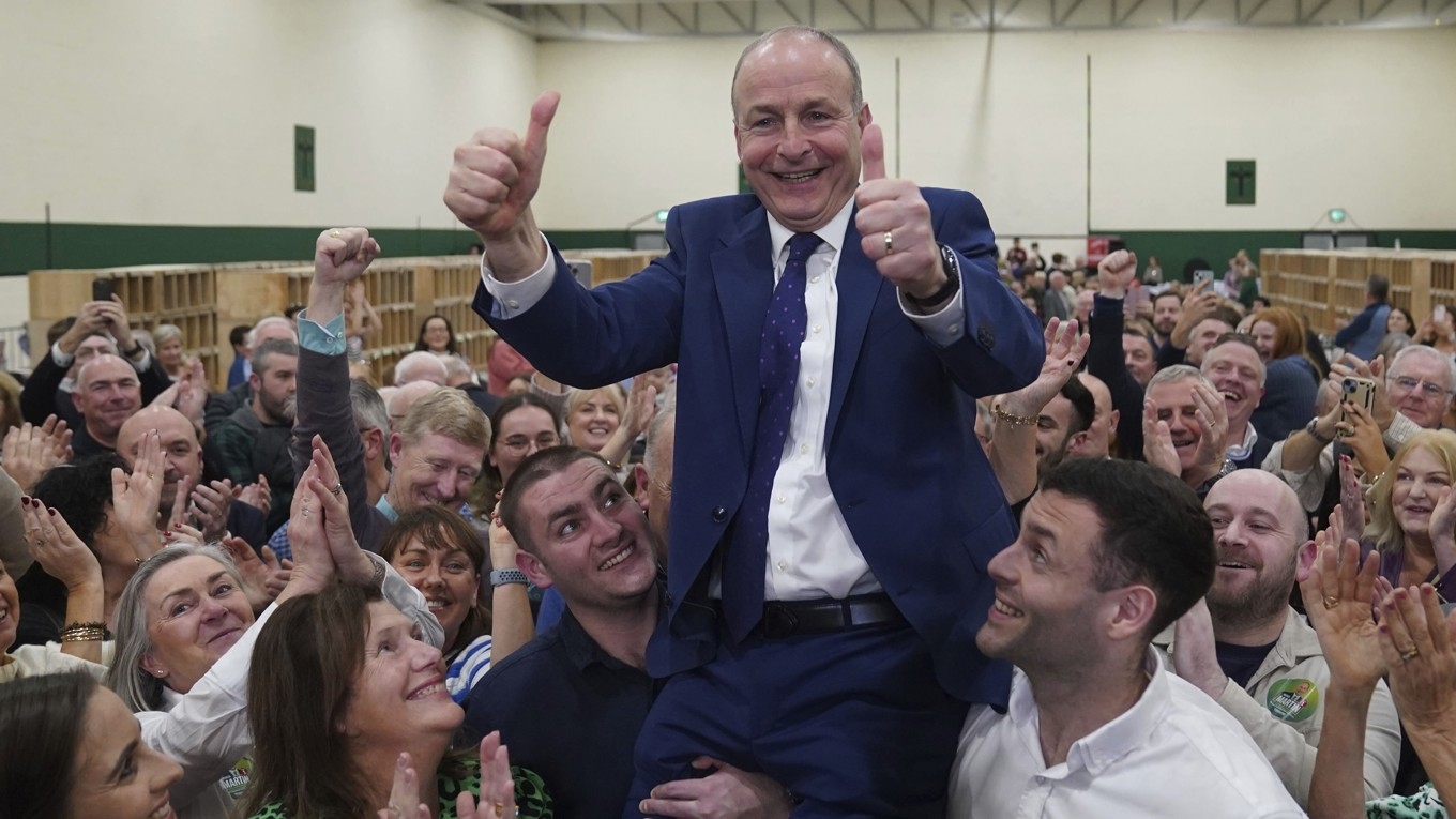 Den högerliberala irländska partiet Fianna Fáils ledare Micheal Martin hissas av sina söner på partiets valvaka i Cork. Foto: Jacob King/AP/TT