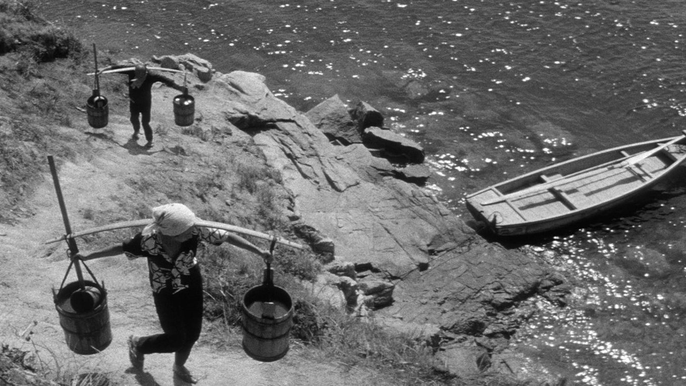 Skådespelarna fick lära sig bära tunga tunnor med vatten, så att deras arbete skulle se naturligt ut. Foto: Kaneto Shindo och Kiyomi Kuroda