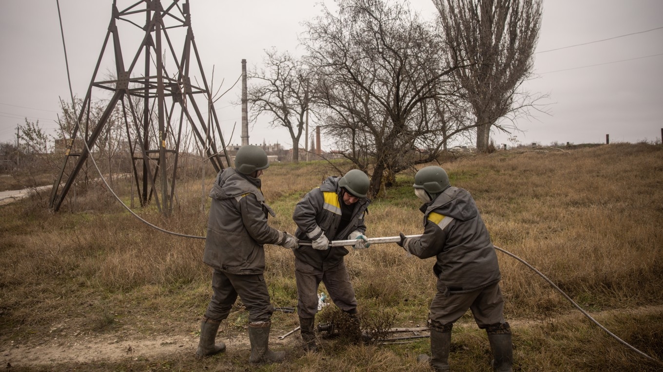 På bilden, som är tagen den 1 december 2022, ser man elektriker arbeta med att reparera en förstörd högspänningsledning i Kherson i Ukraina. Foto: Chris McGrath/Getty Images