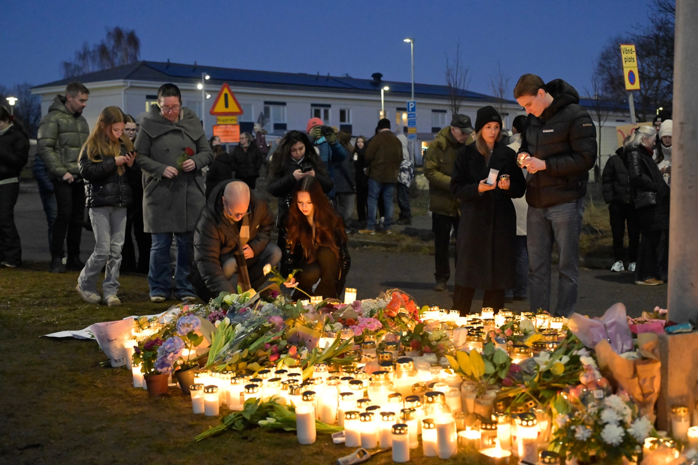 Sörjande samlas för att placera blommor och ljus utanför Campus Risbergska i Örebro dagen efter skolskjutningen som krävde 11 människoliv. Foto: Anders Wiklund/TT