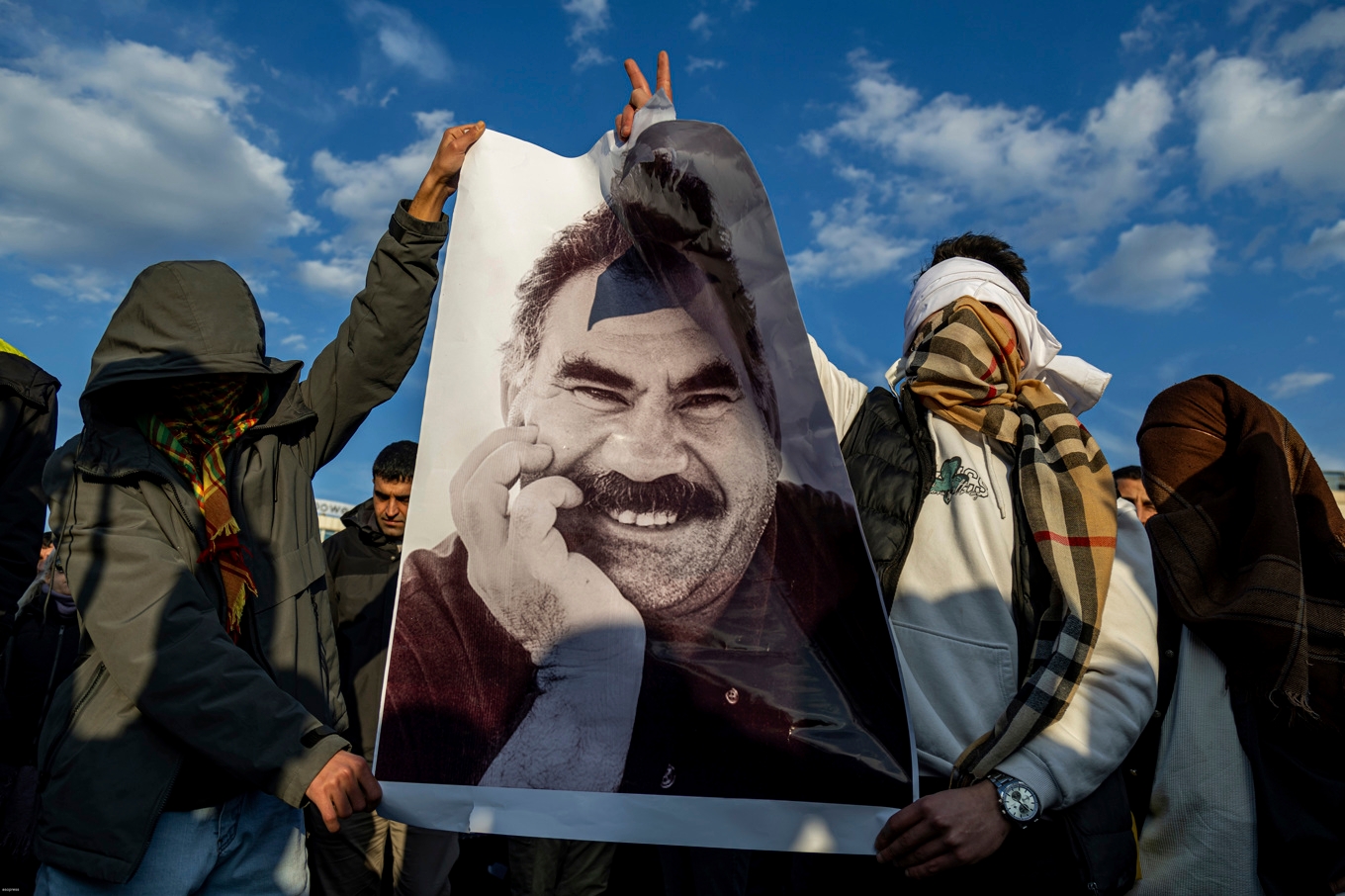 Personer håller upp en bild på PKK:s fängslade ledare Abdullah Öcalan när de samlats för att ta del av hans uttalande som lästes upp av prokurdiska partiet DEM på torsdagen. Bild: Metin Yoksu/AP/TT