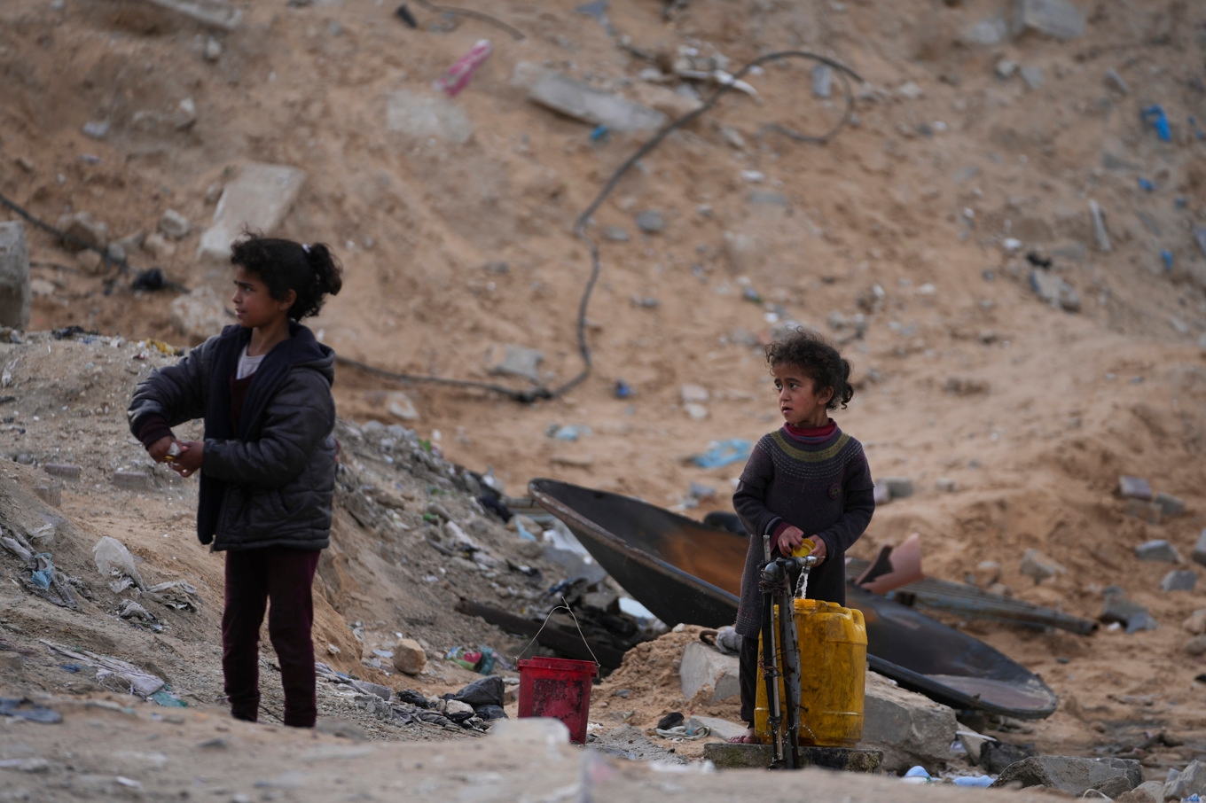 Fördrivna palestinska barn som hämtar vatten väster om Gaza stad i söndags. Foto: Jehad Alshrafi/AP/TT