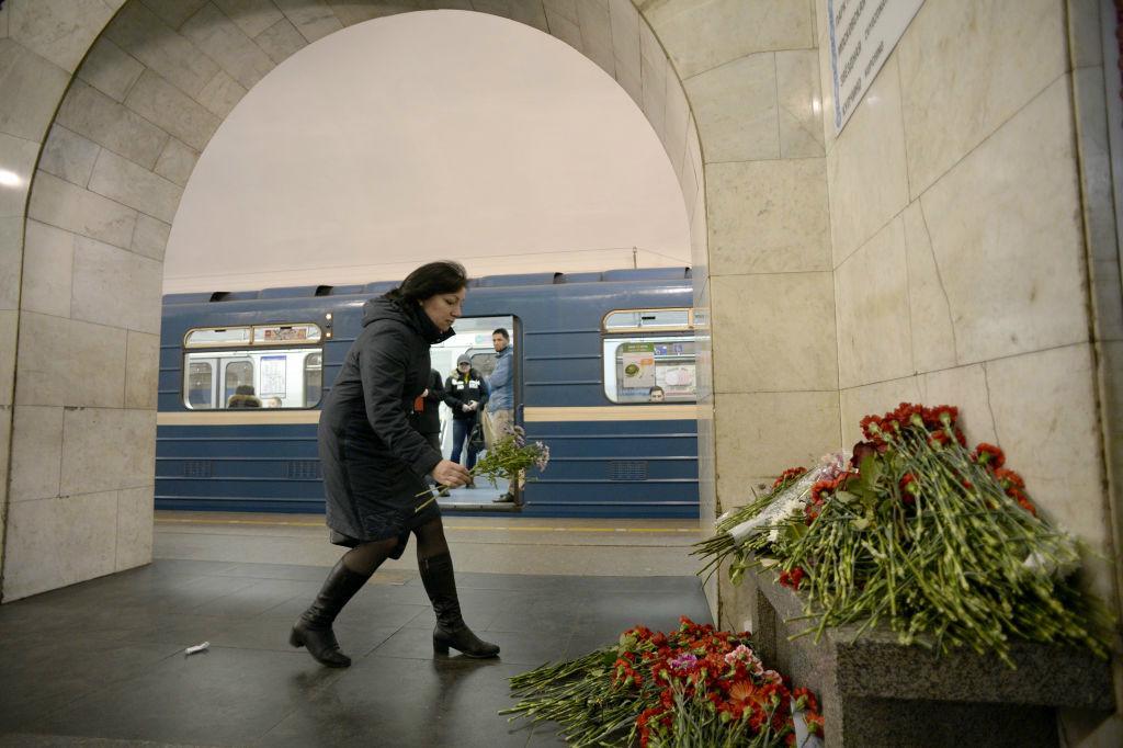 
En kvinna lämnar blommor till offrens minne på platformen vid Tekniska institutionens station. Foto: Olga Maltseva /AFP/Getty Images                                            