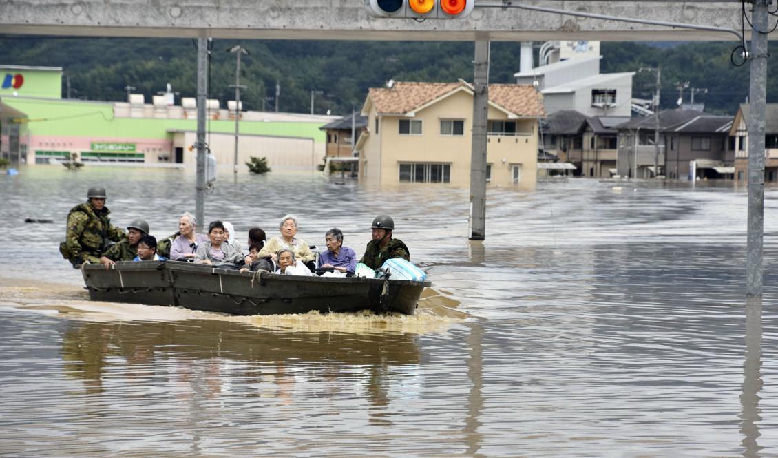 
En grupp människor räddas med båt i den översvämmade staden Kurashiki i den västliga prefekturen Okayama. Foto: Koji Harada/Kyodo News/AP/TT                                            