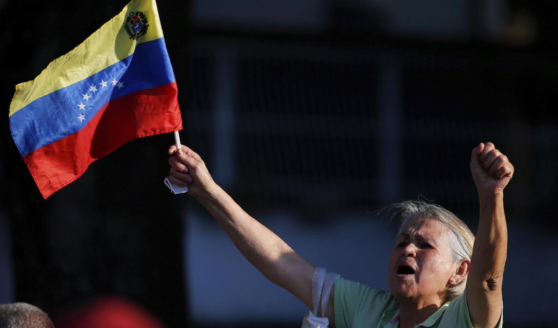 En anhängare av oppositionsledaren Juan Guaido under en demonstration i Caracas, där det i dag väntas nya storskaliga protester. Foto: Fernando Llano/AP/TT-arkivbild