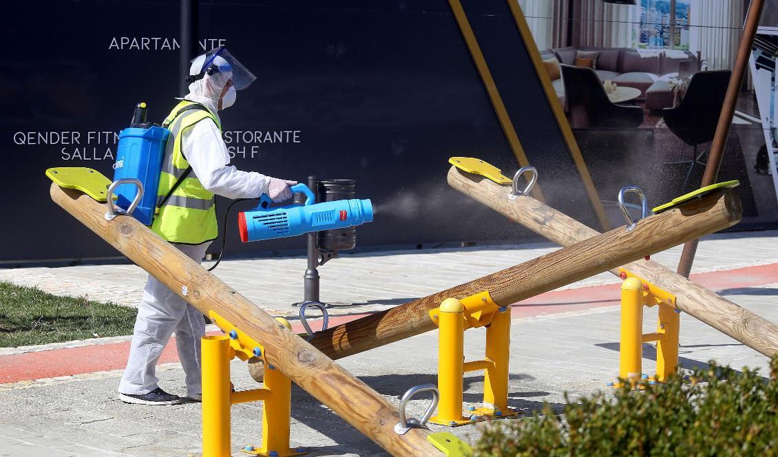 
En man desinficerar en lekplats som åtgärd för att stoppa spridningen av det nya coronaviruset COVID-19 i Tirana i Albanien den 11 mars 2020. Foto: Gent Shkullaku/AFP via Getty Images                                                