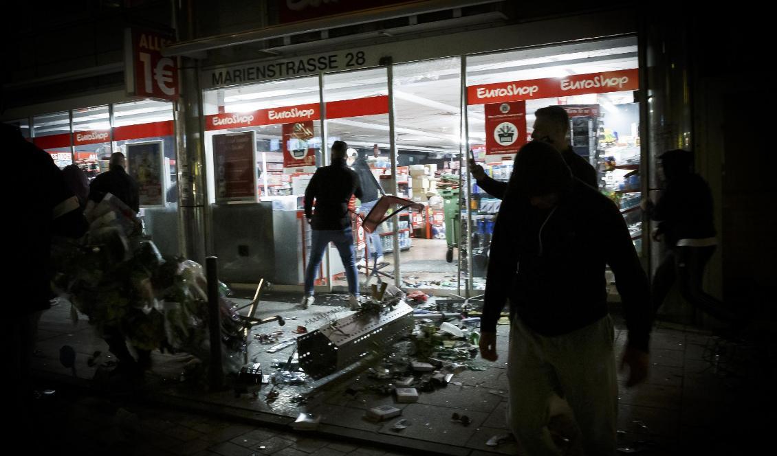 Varor ligger på gatan efter att människor brutit sig in i en butik i Stuttgart under nattens upplopp. Foto: Julian Rettig/AP/TT