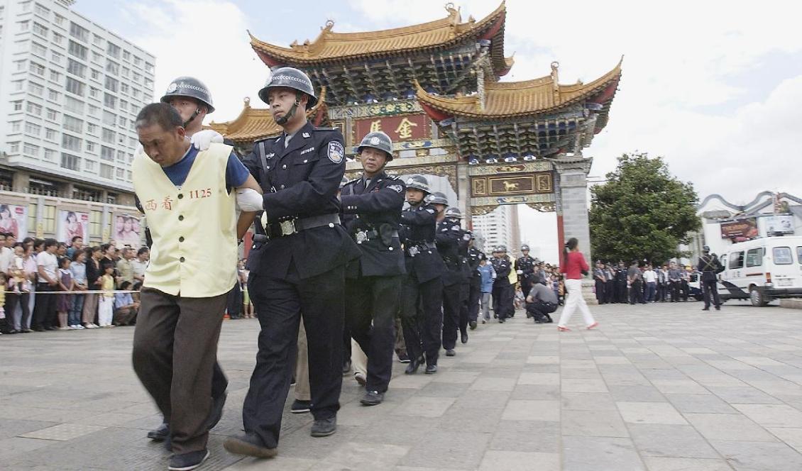
Polis eskorterar brottslingar som vid en offentlig rättegång dömts för kidnappning och säljande av barn i Yunnanprovinsen i Kina i juni 2005. Foto: Shina Photos/Getty Images                                            