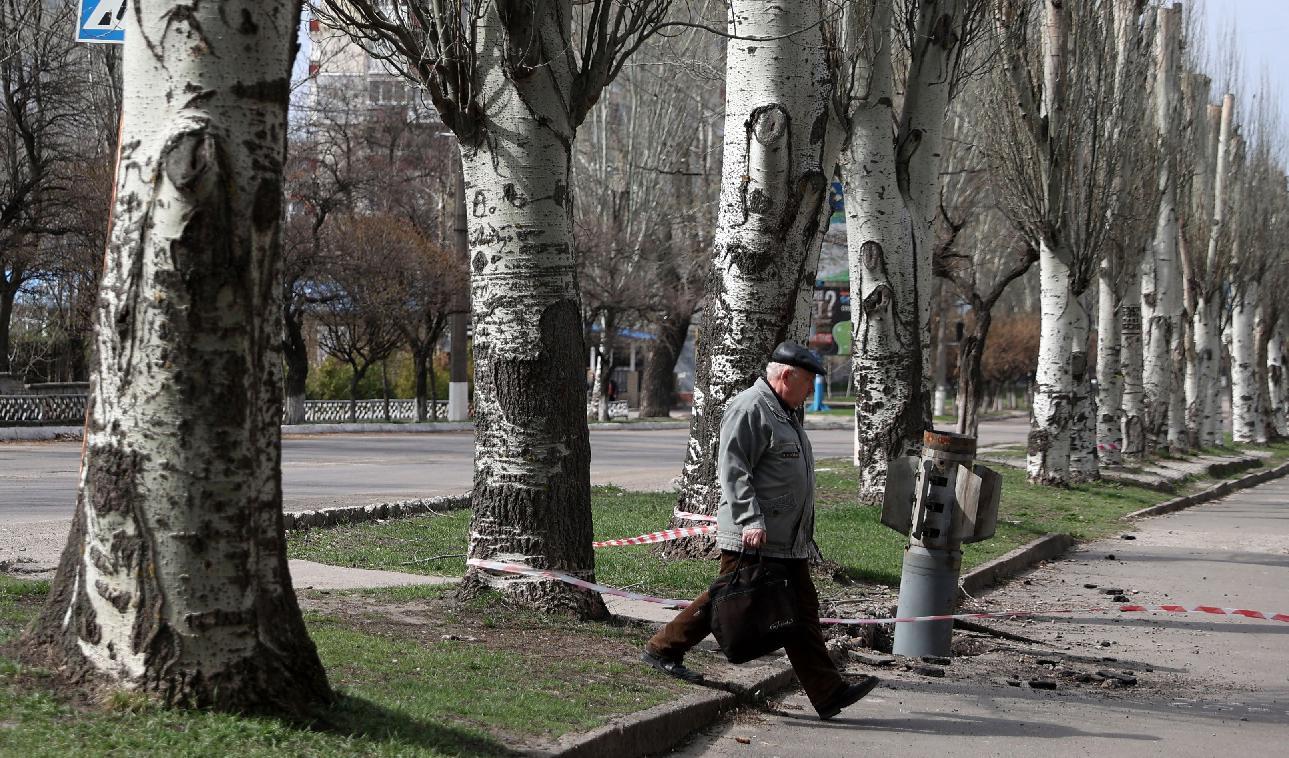 En äldre man passerar en odetonerad förmodad klusterbomb som sköts mot Lysychansk i Luganskregionen i Ukraina den 11 april 2022. Foto: Anatolii Stepanov/AFP via Getty Images