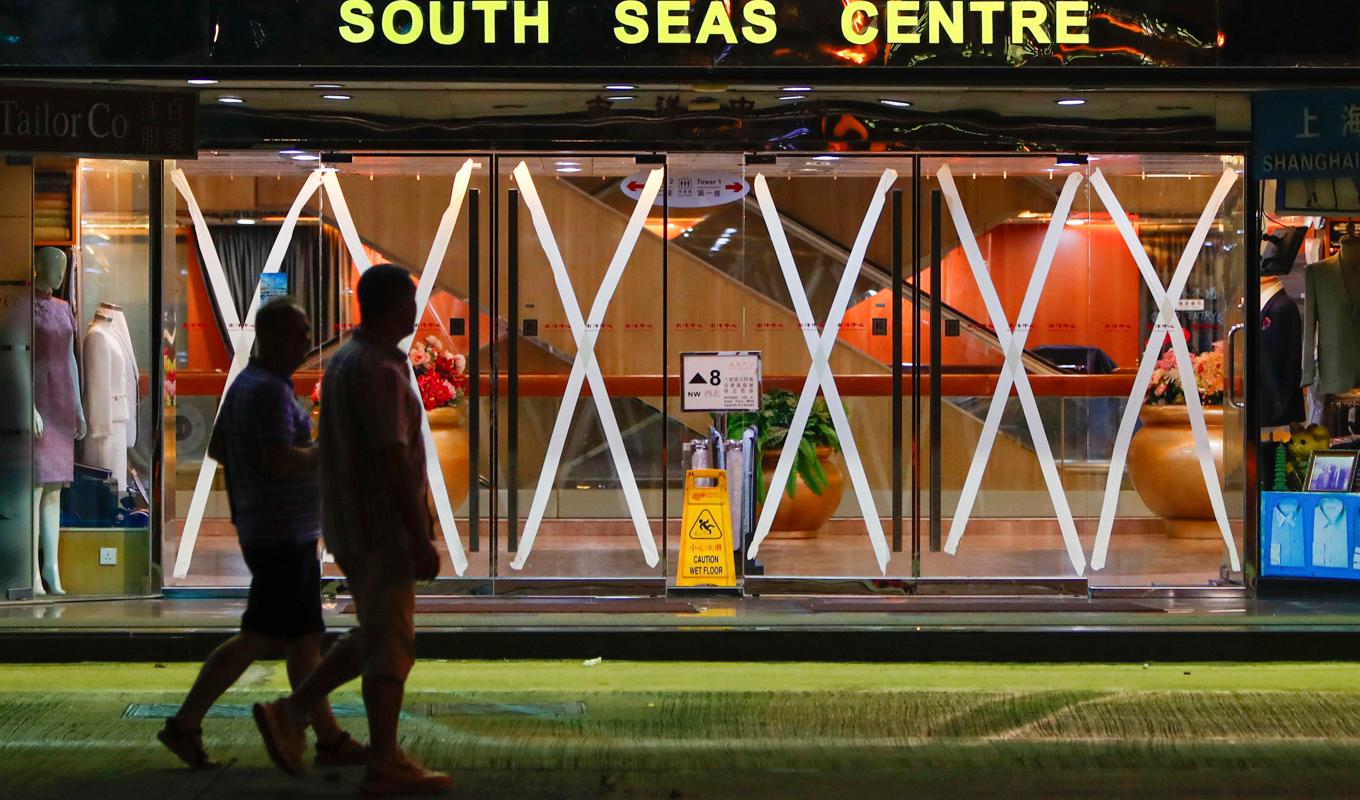 Invånare i Hongkong vid ett köpcentrum som har tejpat sina glasdörrar som en försiktighetsåtgärd när supertyfonen Saola närmar sig. Foto: Daniel Ceng/AP/TT