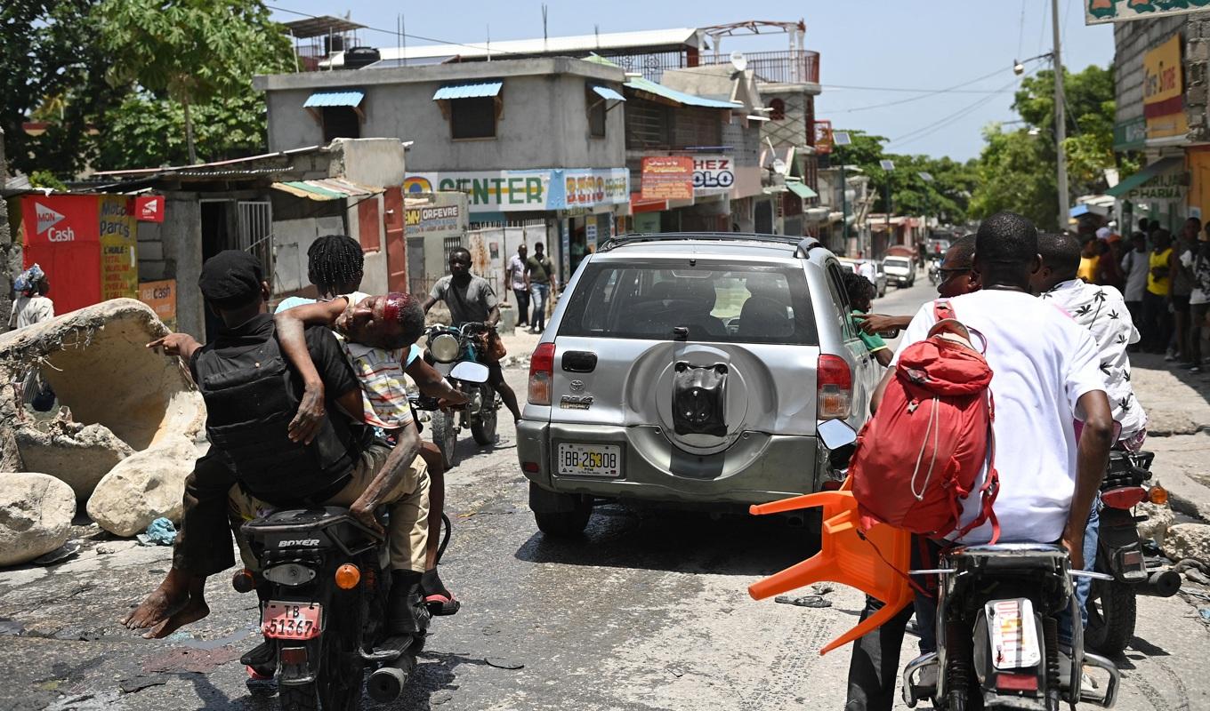 En skadad man transporteras på en motorcykel till ett sjukhus efter en gängskjutning i Port-au-Prince i Haiti den 15 augusti 2023. Foto: Richard Pierrin/AFP via Getty Images