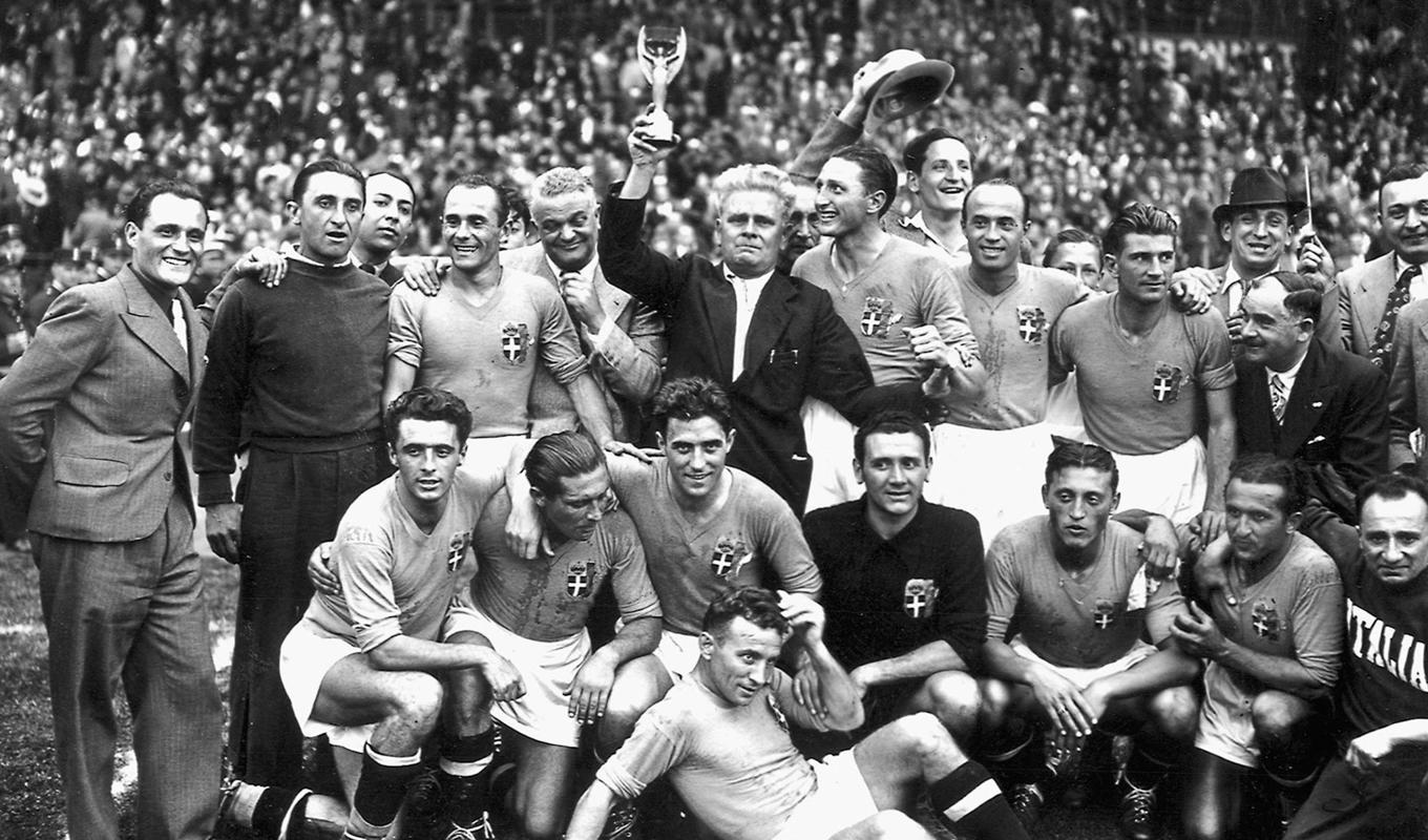 Italienska landslaget ­jublar efter att ha ­slagit Ungern i VM-finalen 1938. Tränaren ­Vittorio Pozzo lyfter bucklan. Foto: STAFF/AFP via Getty Images