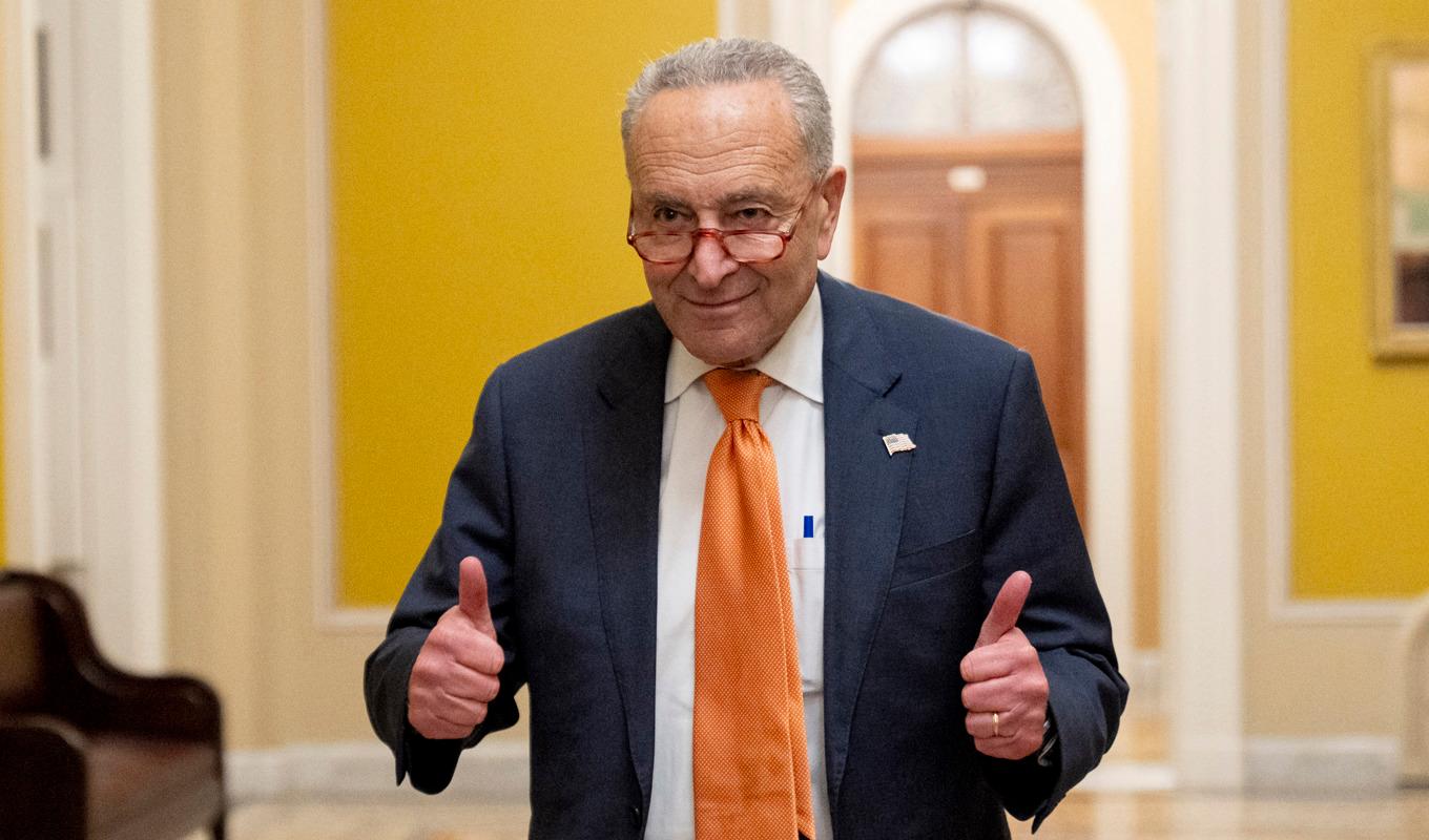 Senatens majoritetsledare, demokraten Chuck Schumer, ger tummen upp efter att förslaget röstats igenom. Foto: Andrew Harnik/AP/TT