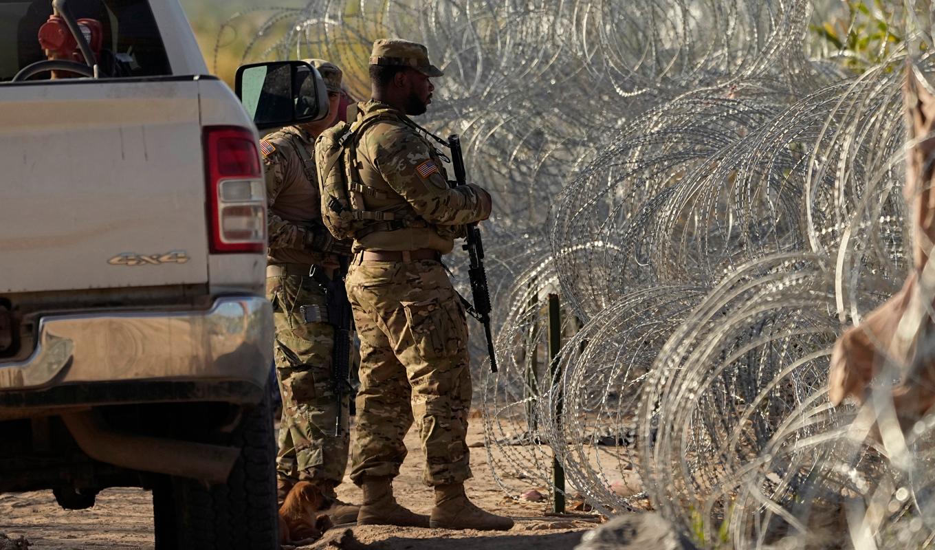 Gränsvakter vid barriär och traggtråd vid USA:s gräns mot Mexiko, vid Rio Grande och Eagle Pass i delstaten Texas. Foto: Eric Gay/AP/TT