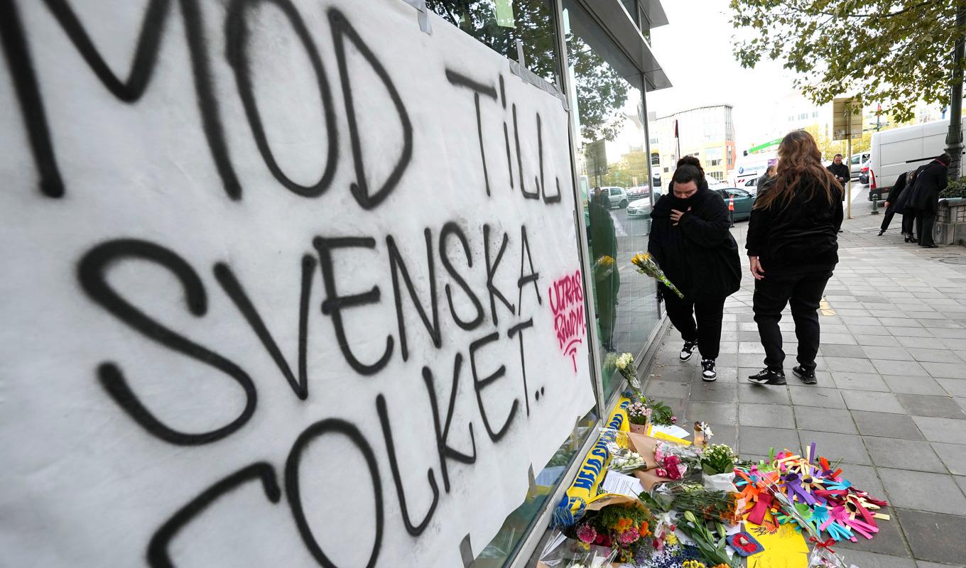 Människor lämnar blommor för att hedra offren för skjutningen i Bryssel i måndags kväll. Foto: Martin Meissner/AP/TT