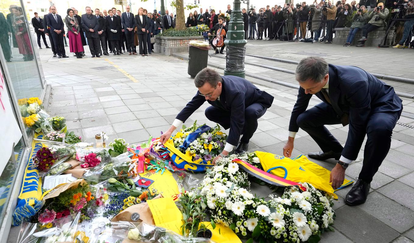 Sveriges statsminister Ulf Kristersson och Belgiens premiärminister Alexander De Croo lägger blommor och svenska fotbollströjor på en minnesceremoni vid brottsplatsen. Foto: Martin Meissner/AP/TT