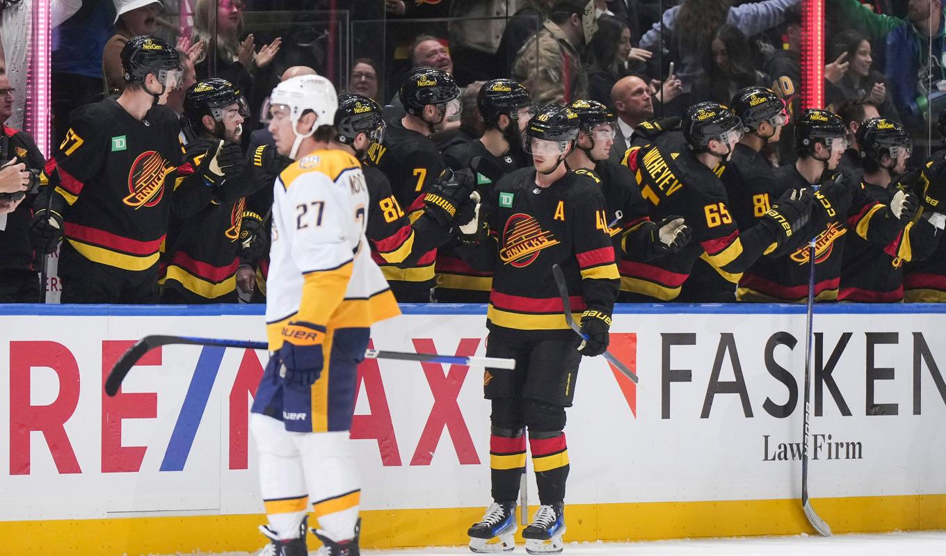 Elias Pettersson gratuleras av sina lagkamrater efter att han gjort sitt andra mål. Foto: DARRYL DYCK/AP/TT