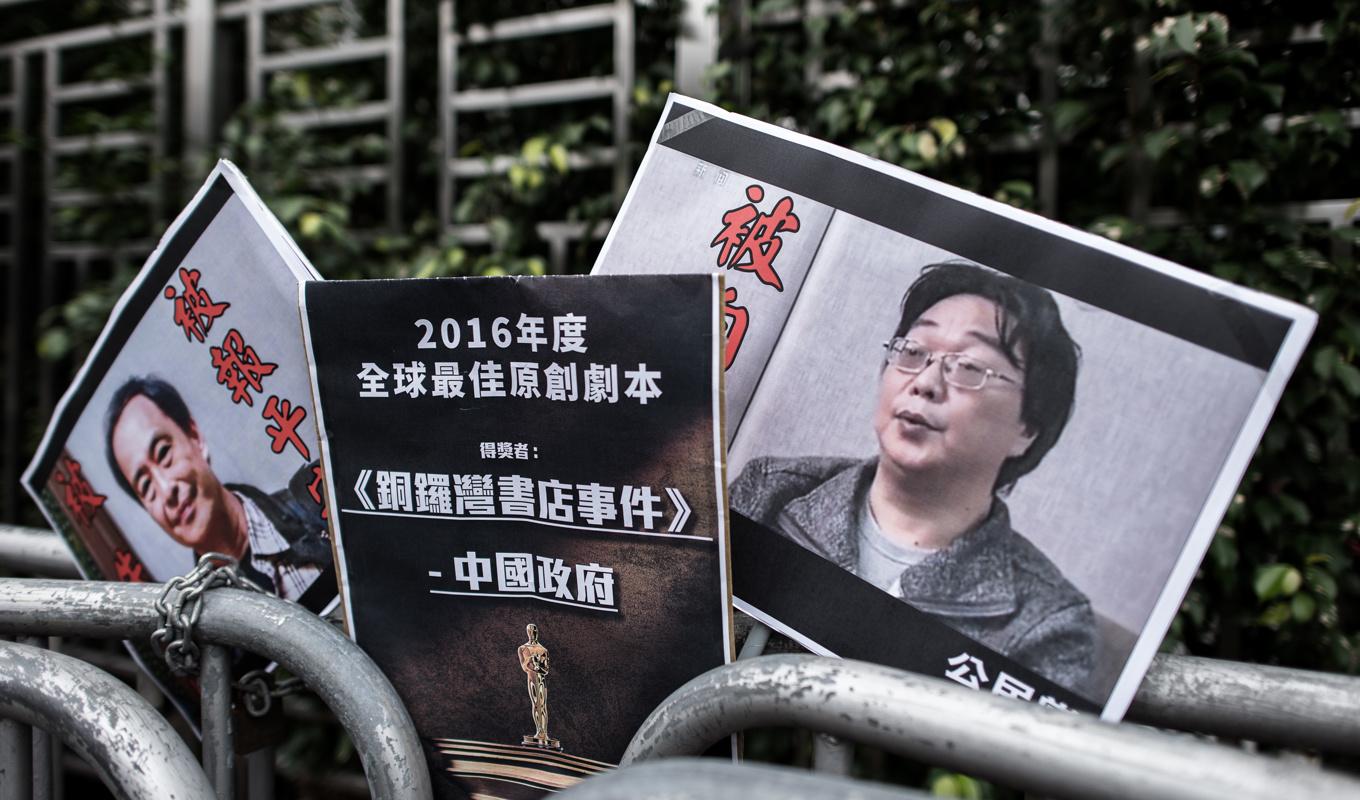 På höger sidan syns ett plakat med Gui Minhai på bild vid Kinas sambandskontor i Hongkong den 19 januari 2016. Foto: Philippe Lopez/AFP via Getty Images