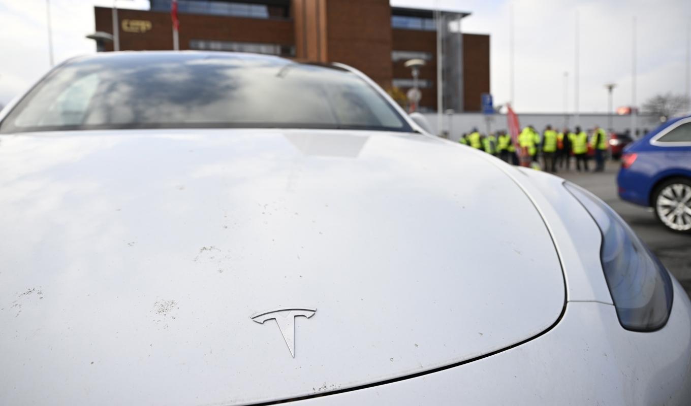 En Teslabil i förgrunden till konfliktande transportarbetare vid Malmö hamn. Arkivbild. Foto: Johan Nilsson/TT