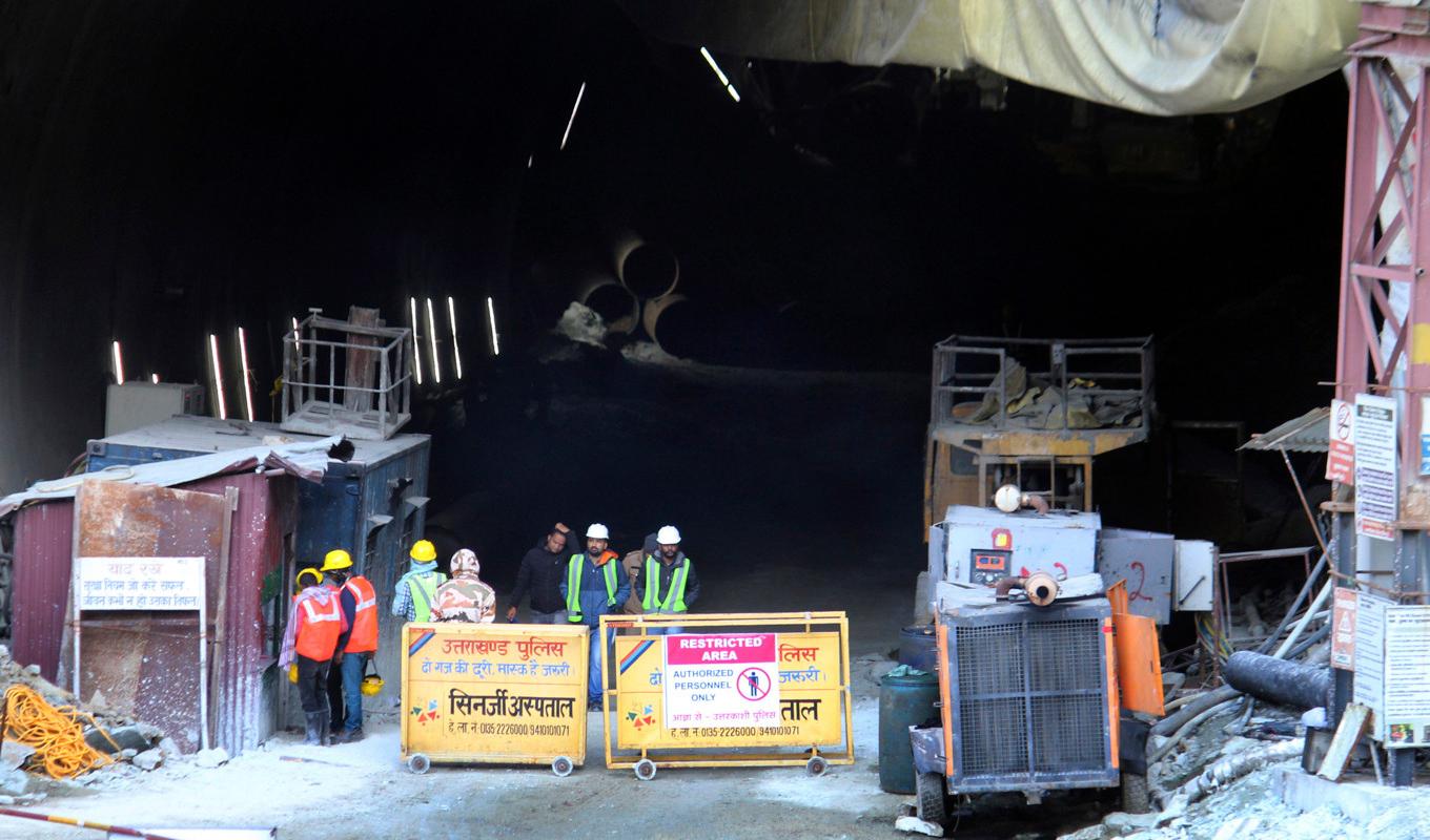 Räddningspersonal och säkerhetspersonal vid ingången till tunneln som rasade den 12 november. Bilden togs i fredags. Foto: AP/TT