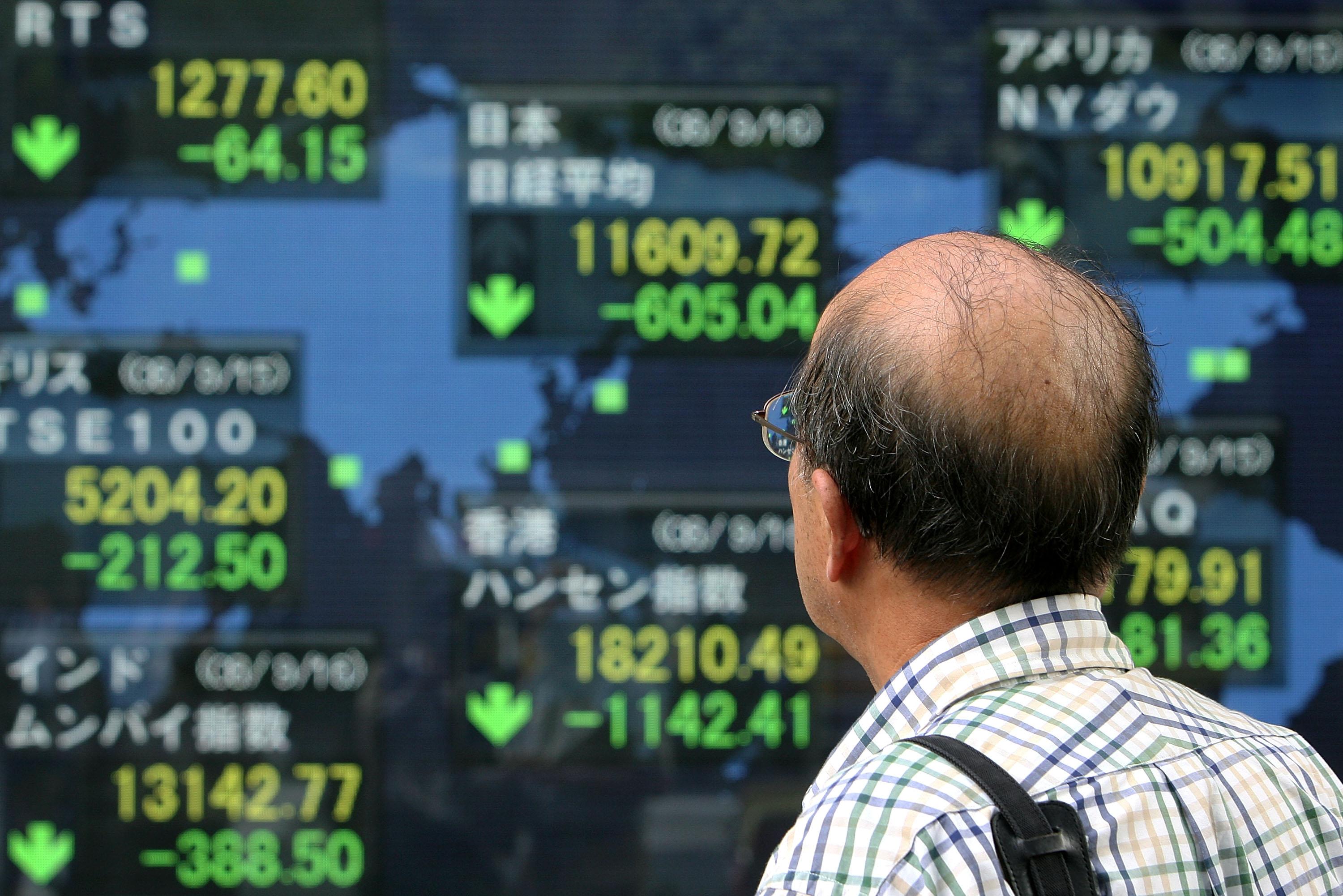 En man tittar på en elektronisk tavla i Tokyo. Foto: Kiyoshi Ota/Getty Images