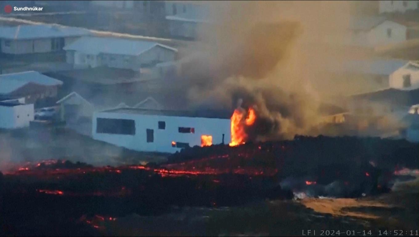 Lava strömmar in i Grindavik och sätter eld på husen närmast sprickan. Arkivbild. Foto: LIVEFROMICELAND.IS/AP/TT