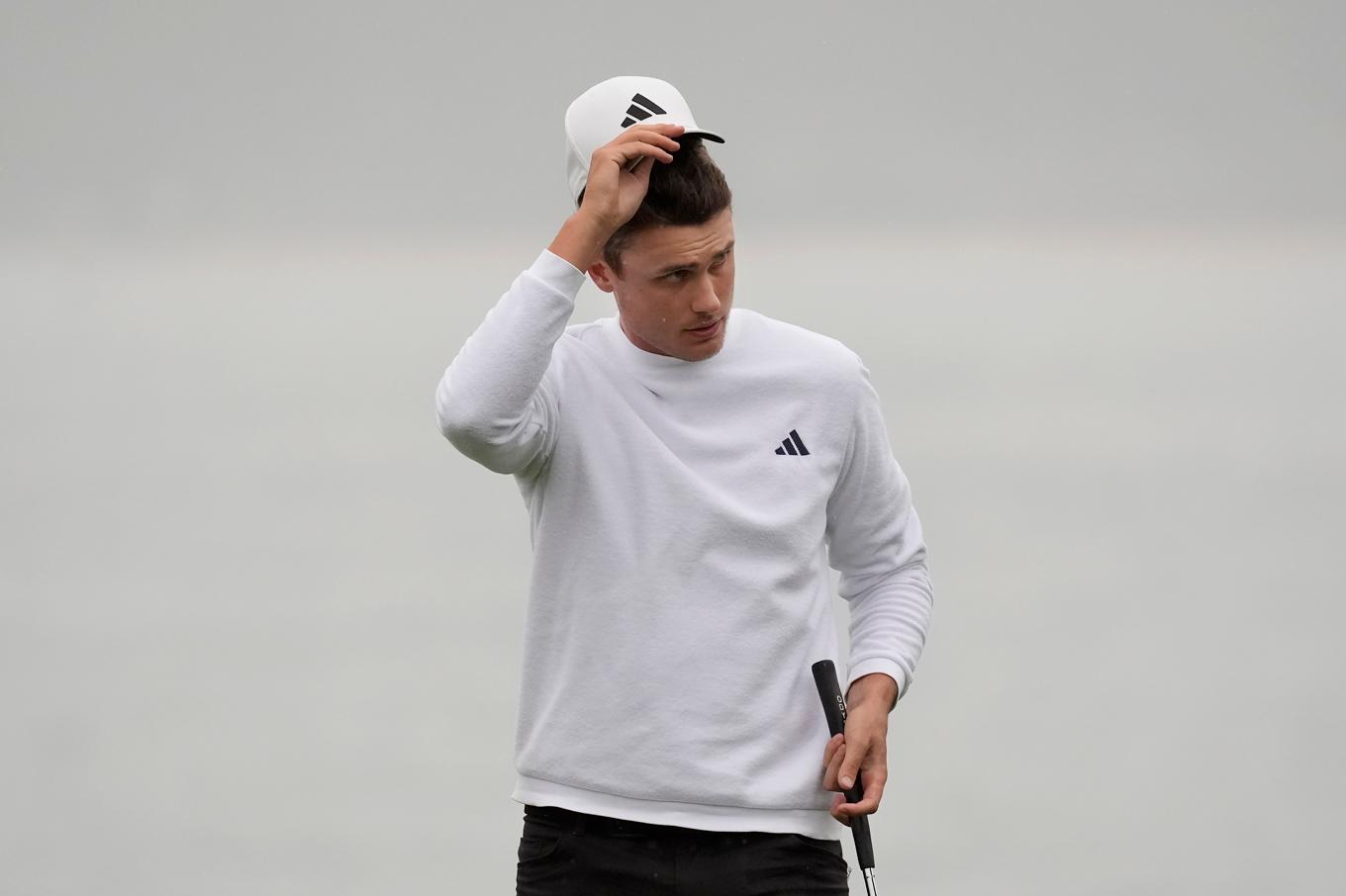 Svenske Ludvig Åberg lyfter på kepsen efter en birdie på sista hålet på Pebble Beach. Sammanlagt blev det fem birdies under tredje rundan. Foto: Ryan Sun/AP/TT