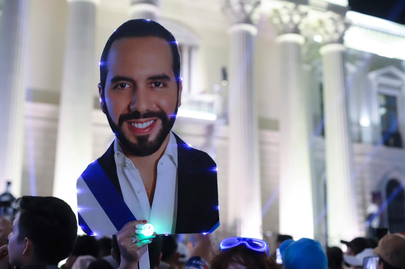 En anhängare till president Nayib Bukele håller upp ett utskuret foto av honom i San Salvador på söndagskvällen. Foto: Salvador Melendez/AP/TT