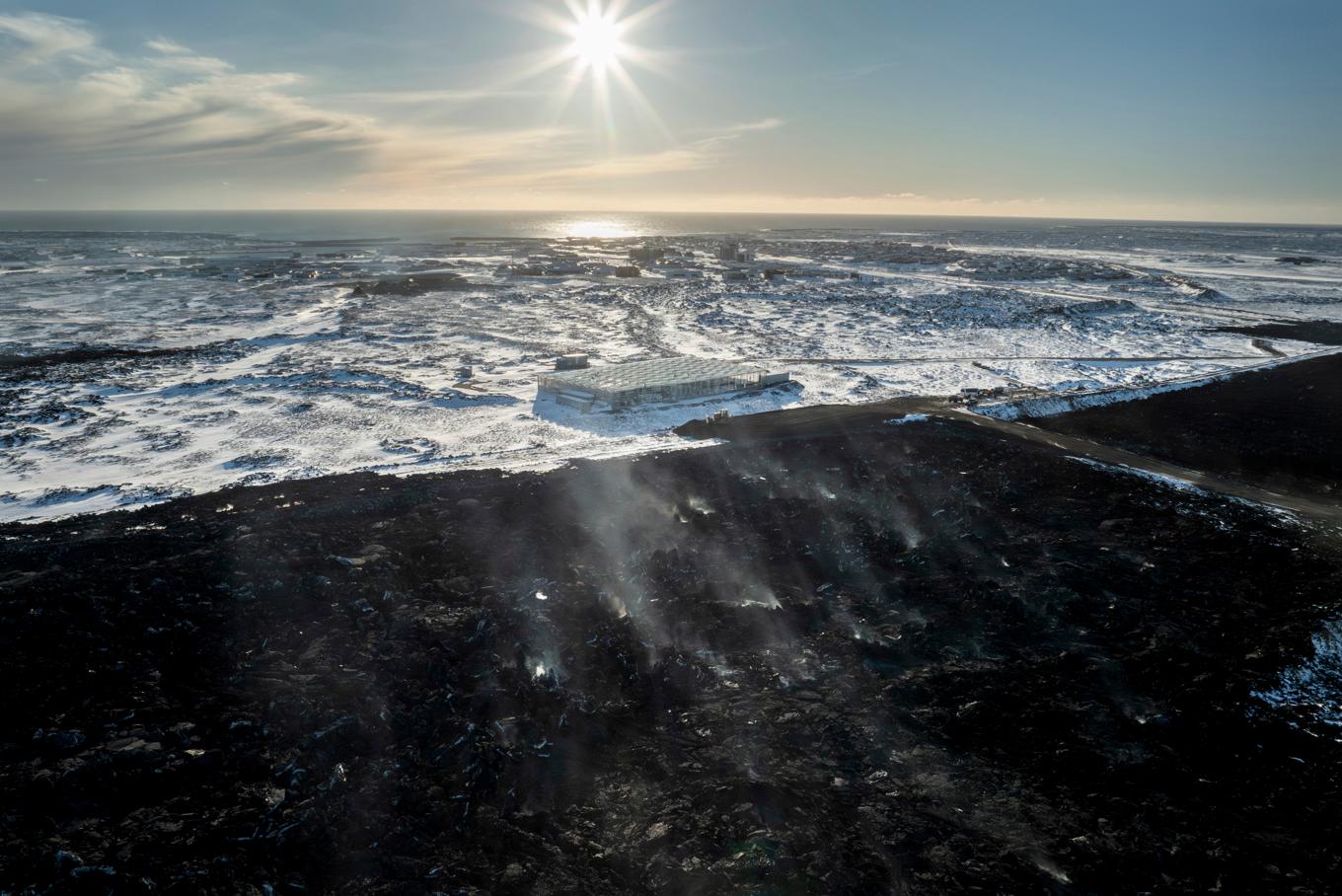 Ett lavafält, nere i bild, vid Grindavík, efter utbrottet i januari. Bilden är från häromdagen. Foto: Marco Di Marco/AP/TT