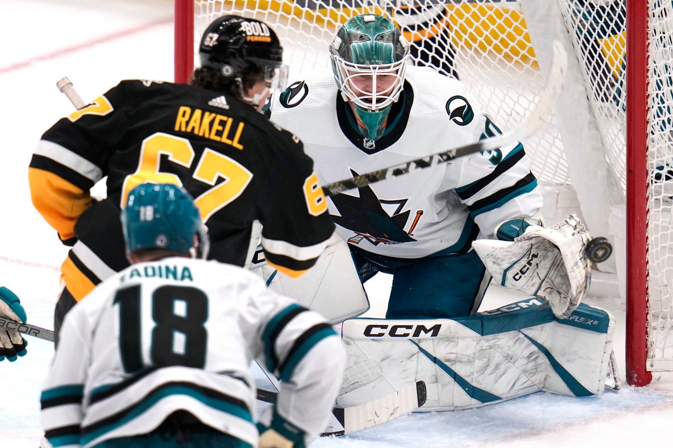 Pittsburghs Rickard Rakell (67) i kamp framför San Joses svenske målvakt Magnus Chrona under mötet som slutade med 6–3-vinst för Pittsburgh. Foto: Gene J. Puskar/AP/TT