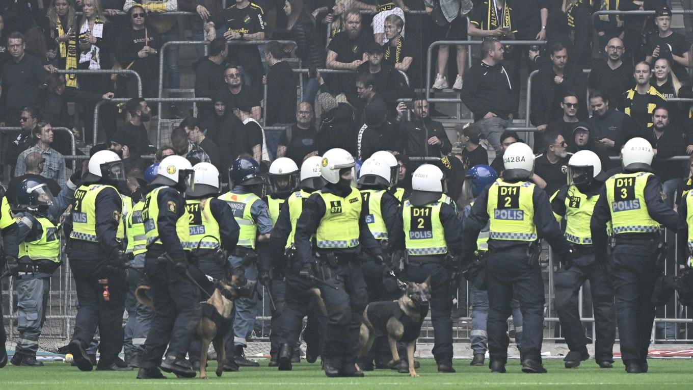 Här har kravallutrustad polis med hundar lyckats tränga tillbaka  AIK-supportrarna som stormade planen. Foto: Jonas Ekströmer/TT