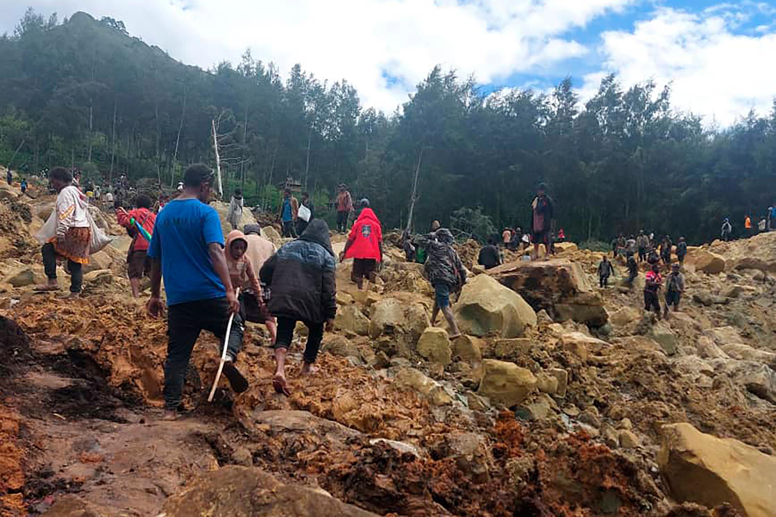 Arbetet med att försöka få fram människor som begravts i skredet pågår. Foto: Benjamin Sipa/International Organization for Migration via AP/TT