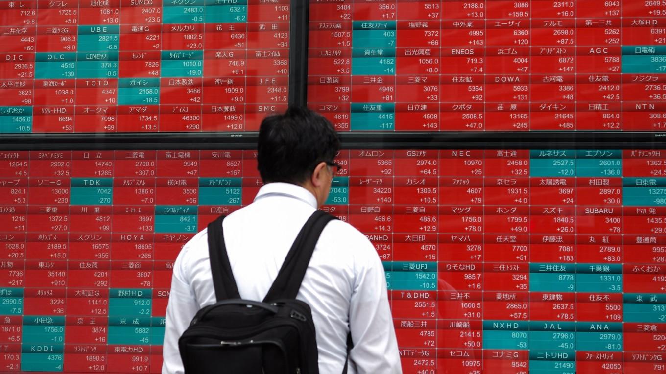 En man tittar på en elektronisk tavla i Tokyo i Japan den 30 april. Foto: Kazuhiro Nogi/AFP via Getty Images