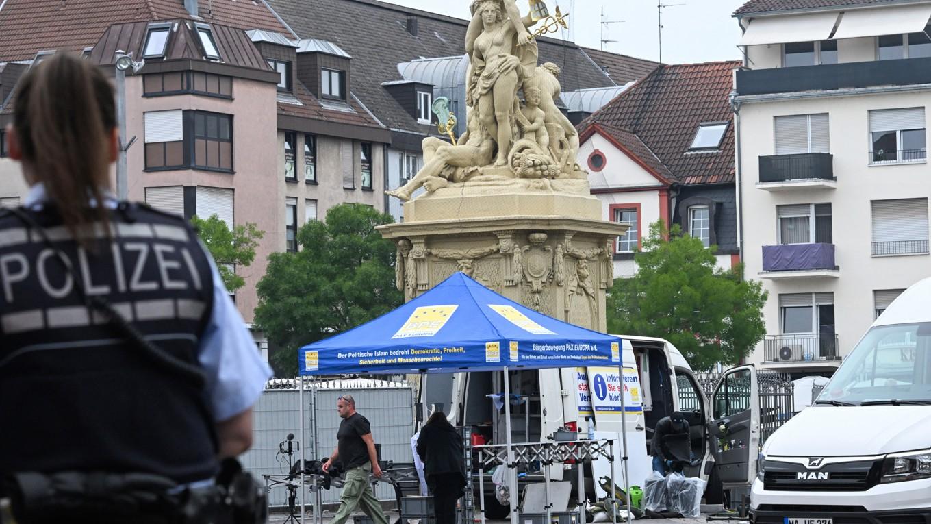 En polis tittar på när arbetare packar ihop utrustningen på platsen där en polisman dödades och flera personer skadades i en knivattack den 31 maj i Mannheim i västra Tyskland. Foto: Kirill Kudryavtsev/AFP via Getty Images