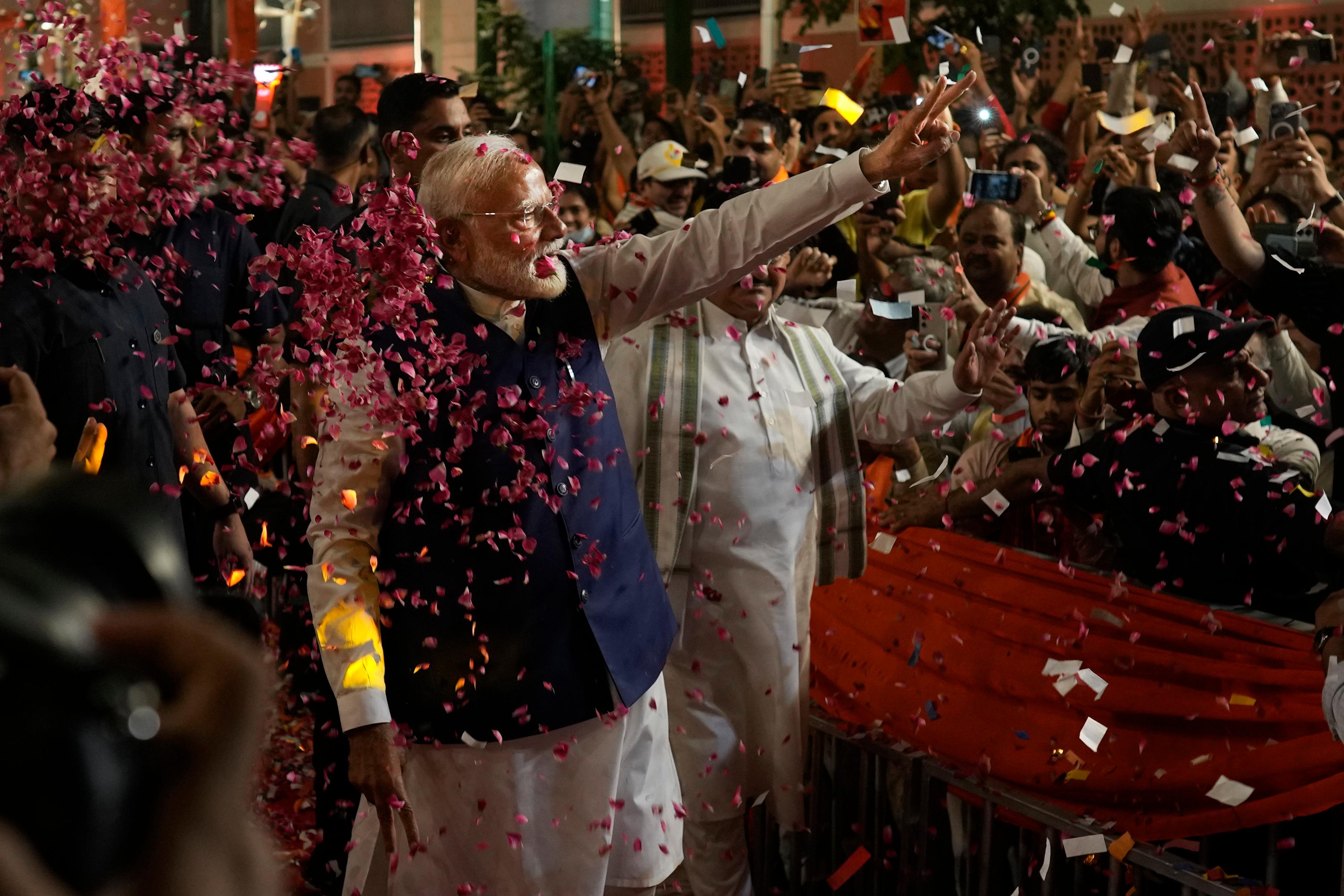 Premiärminister Narendra Modi hälsar på anhängare vid sin valvaka i Delhi. Foto: Manish Swarup/AP/TT