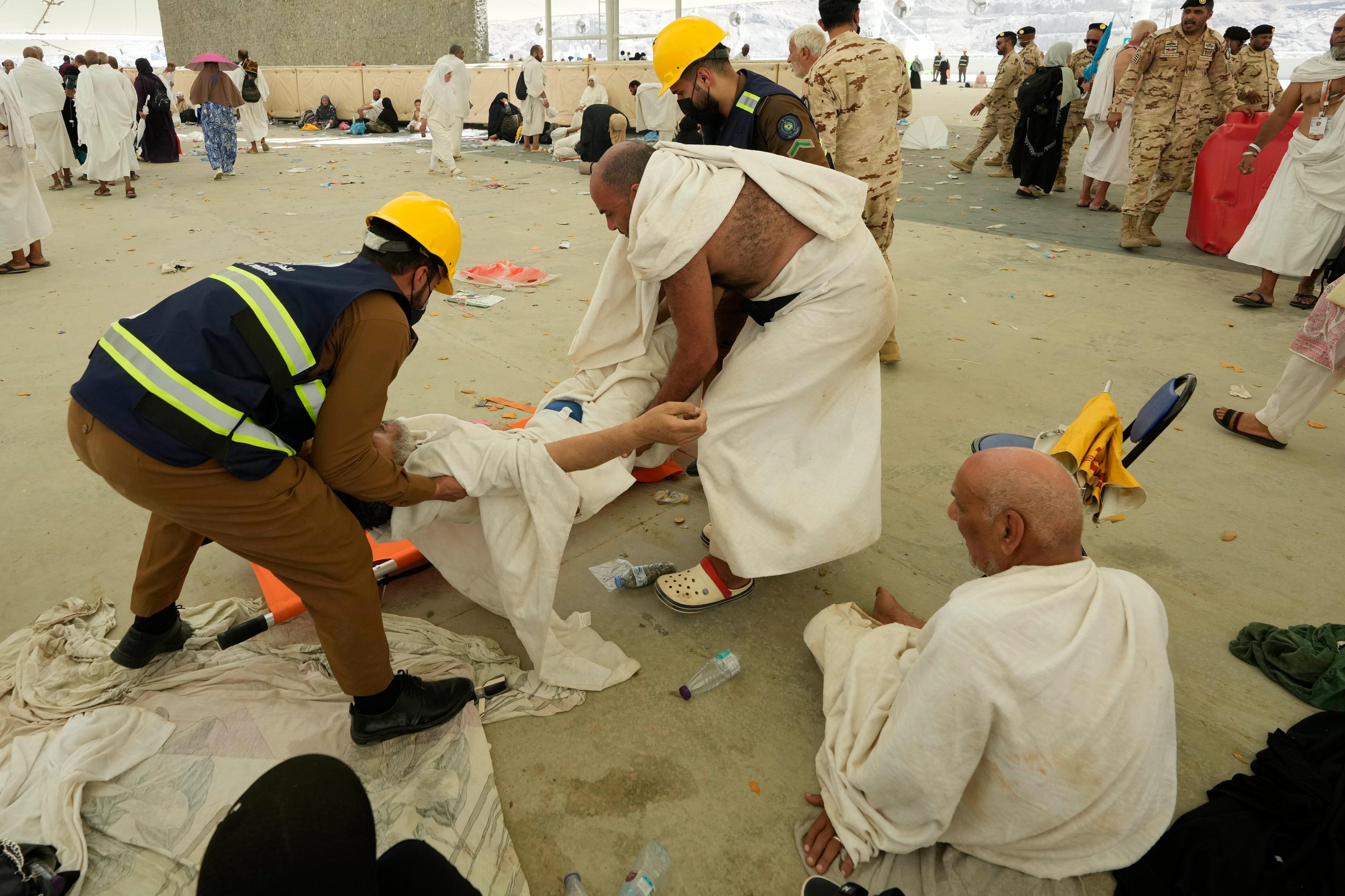En man som kollapsat i värmen får hjälp av vårdpersonal i Mina, nära Mecka, i Saudiarabien. Foto: Rafiq Maqbool/AP/TT