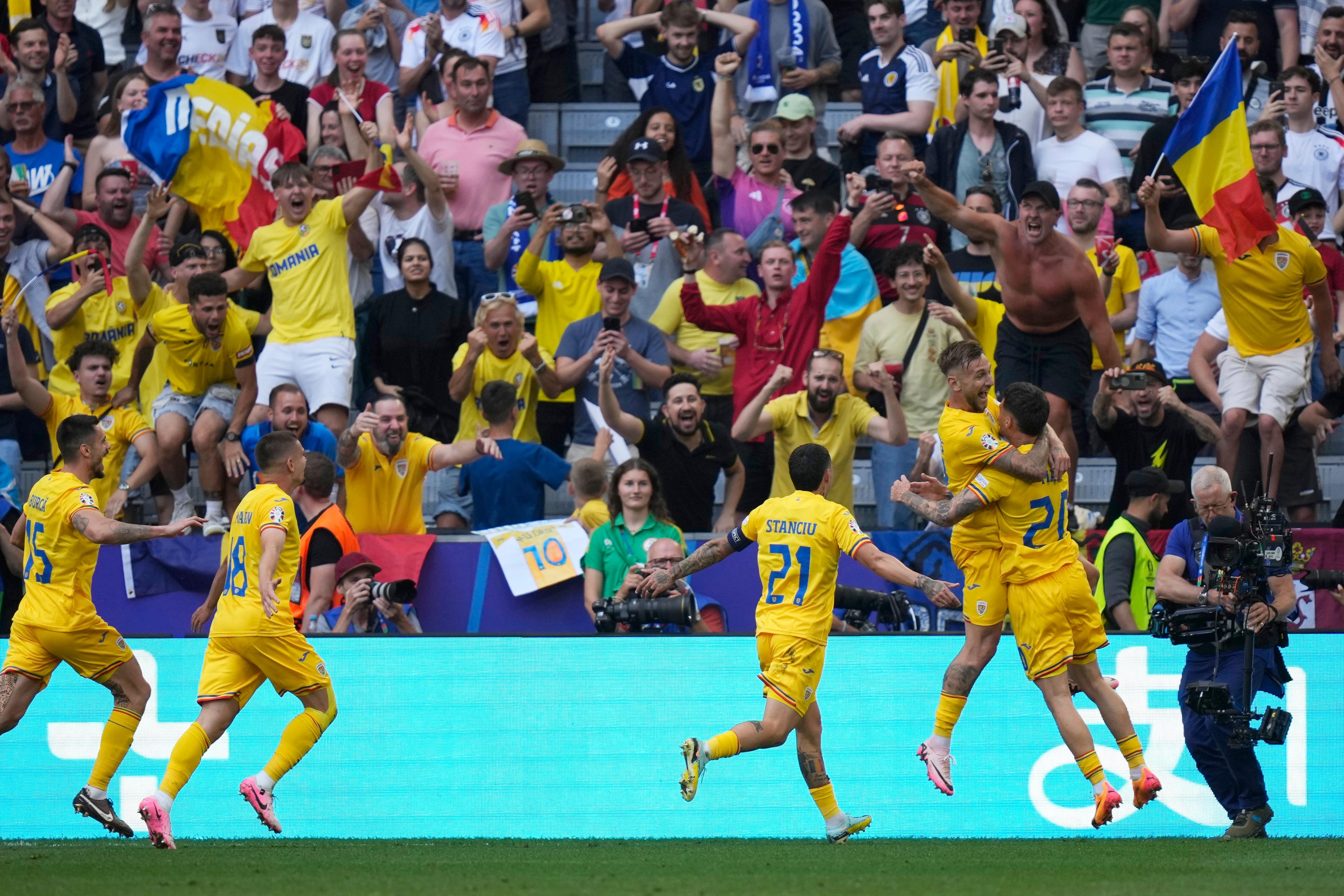 Vild rumänsk glädje efter Denis Dragus 3–0-mål på Ukraina. Foto: Matthias Schrader/AP/TT