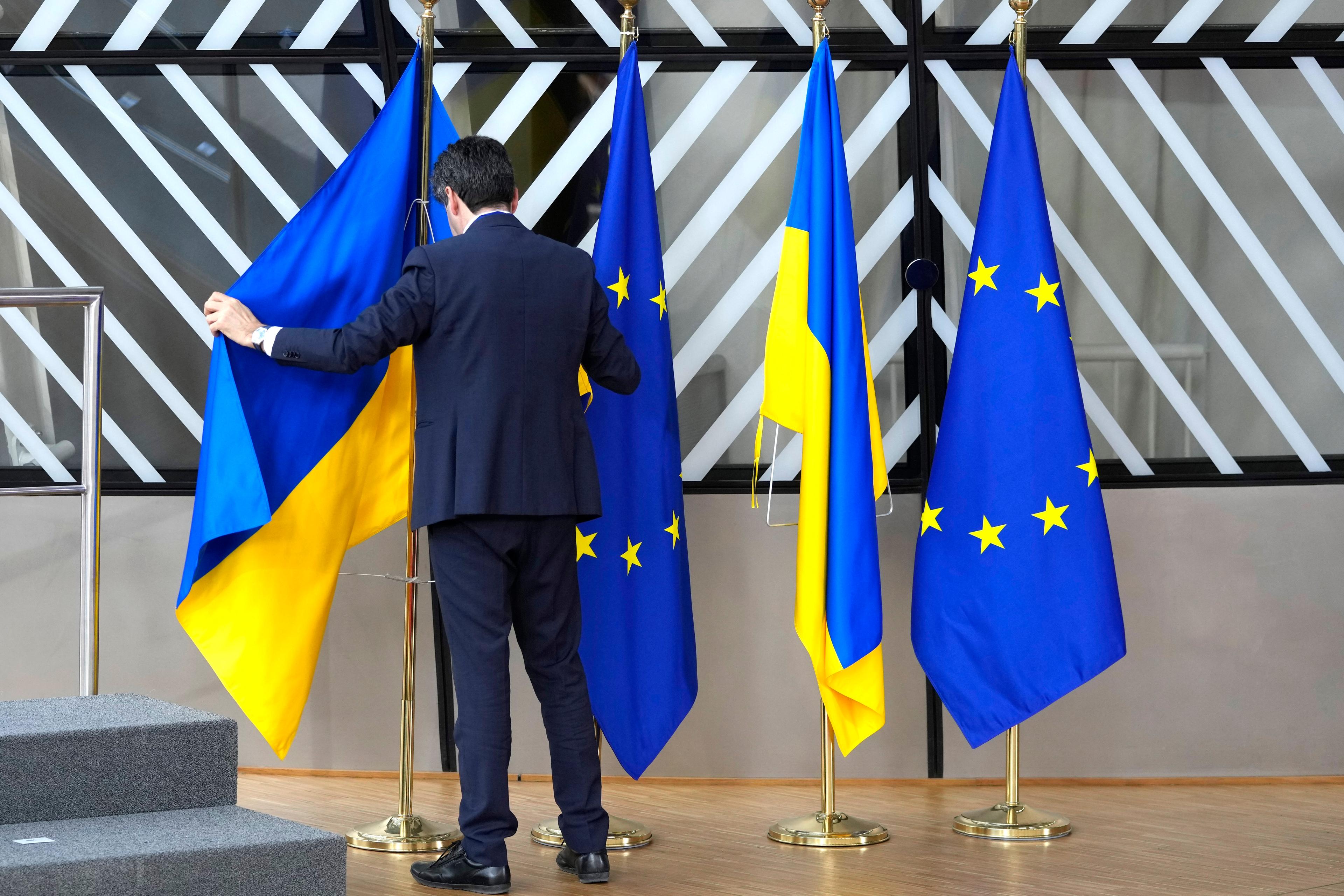 Den ukrainska flaggan hängs på plats inför ett EU-toppmöte i Bryssel 2023. Nu börjar landet sin långa process för att själv bli en del av unionen. Arkivbild. Foto: Virginia Mayo/AP/TT