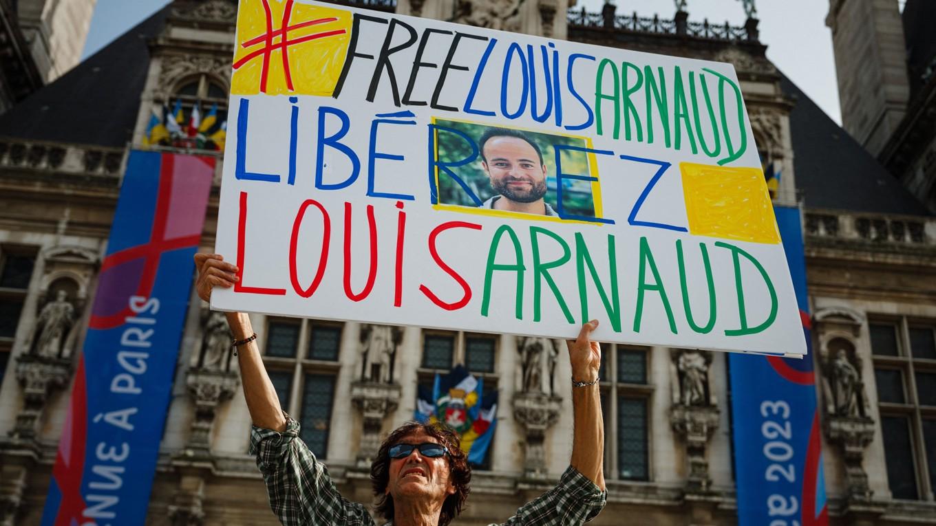 En demonstrant håller upp ett plakat med ett fotografi av Louis Arnaud, en fransk medborgare som har suttit fängslad i Iran, i samband med en protest utanför Hotel de Ville i Paris den 30 september 2023. Dimitar Dilkoff/AFP via Getty Images