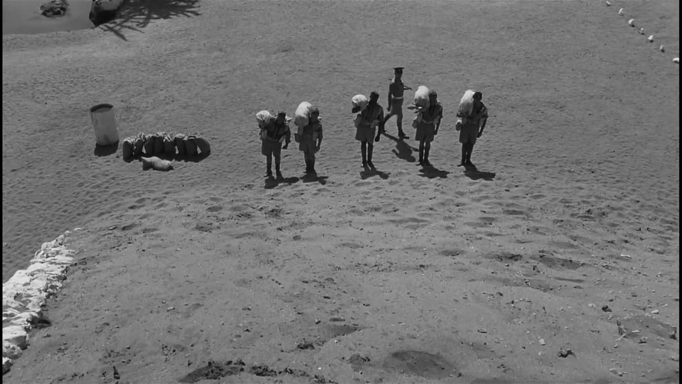 Fångarna kämpar sig upp och ner för kullen. Ett Sisyfosöde i modern tappning. Foto: Sidney Lumet och Oswald Morris