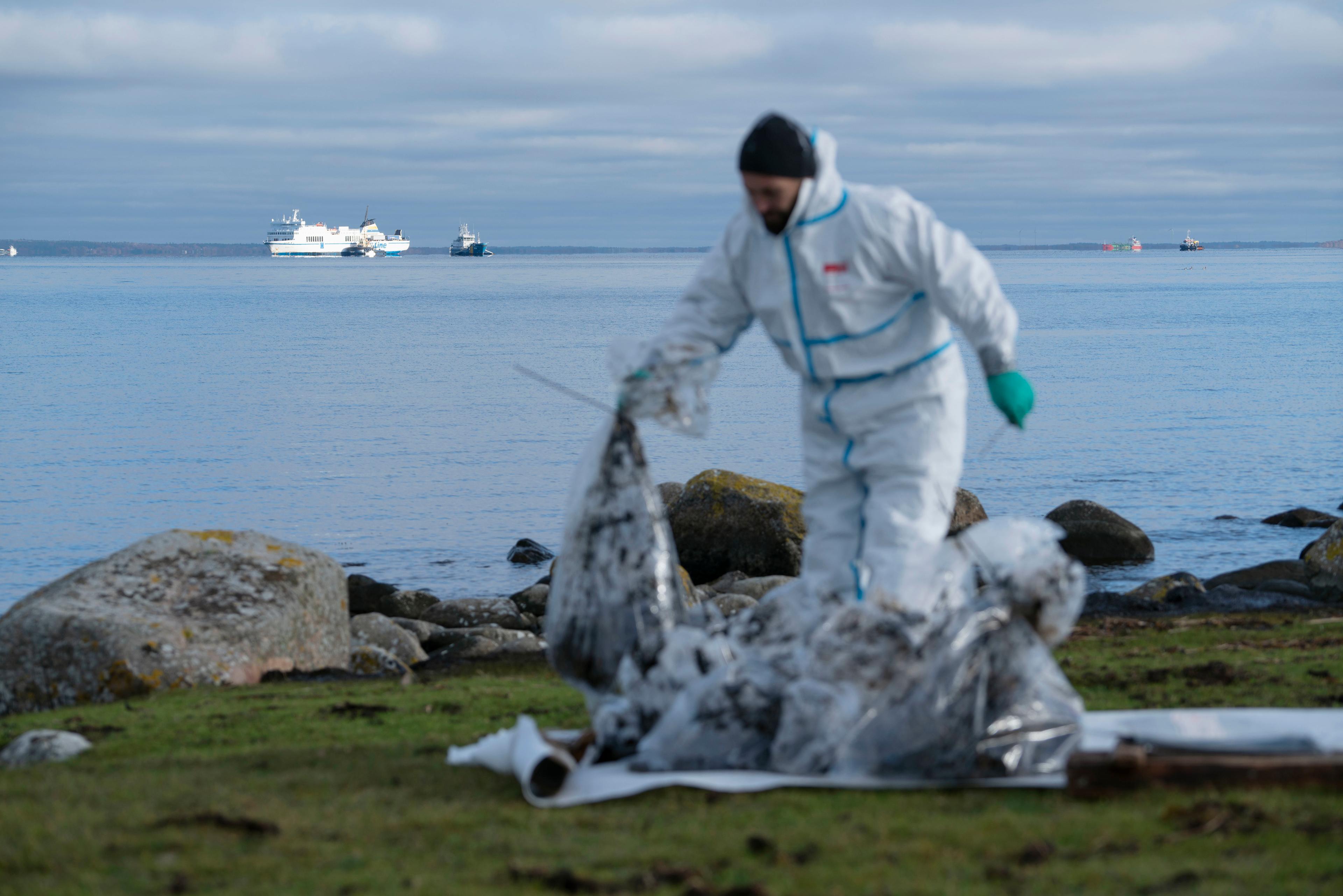 Hösten 2023: I förgrunden ses en person som sanerar på stranden. I bakgrunden passagerarfartyget Marco Polo. Arkivbild. Foto: Ola Torkelsson/TT