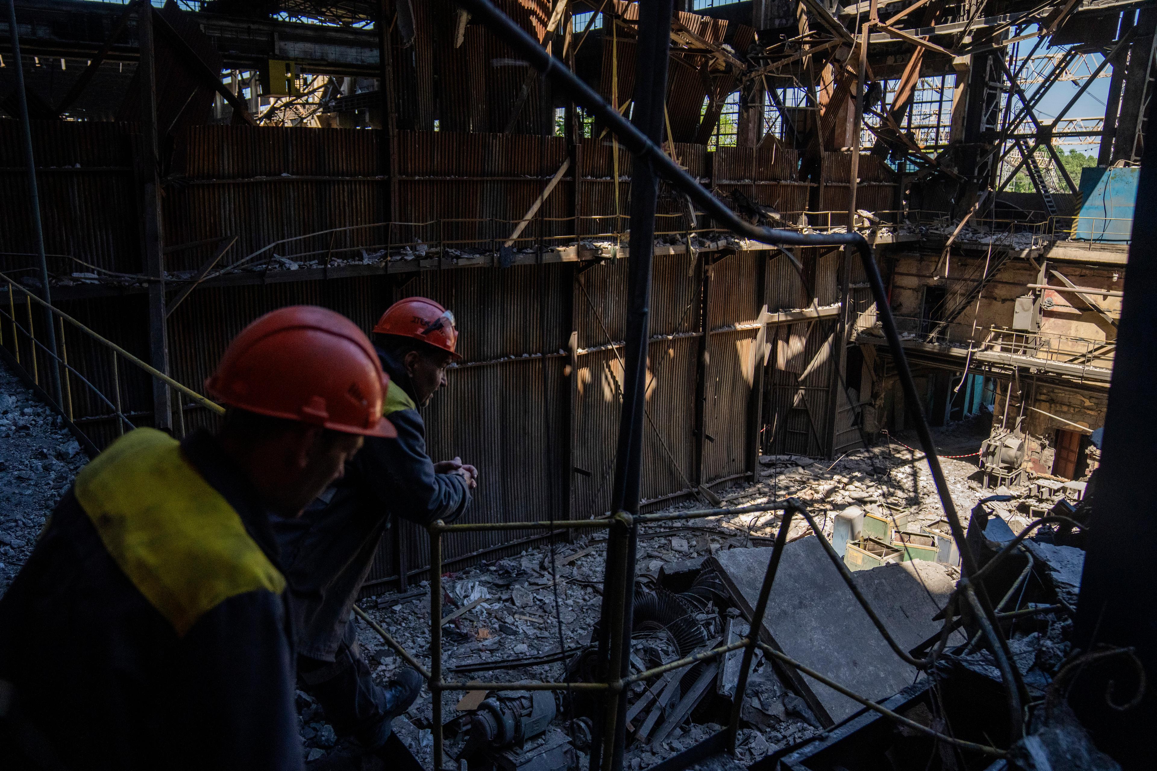 Arbetare står i ett skadat värmekraftverk i Ukraina efter en rysk attack i maj 2024. Foto: Francisco Seco/AP/TT