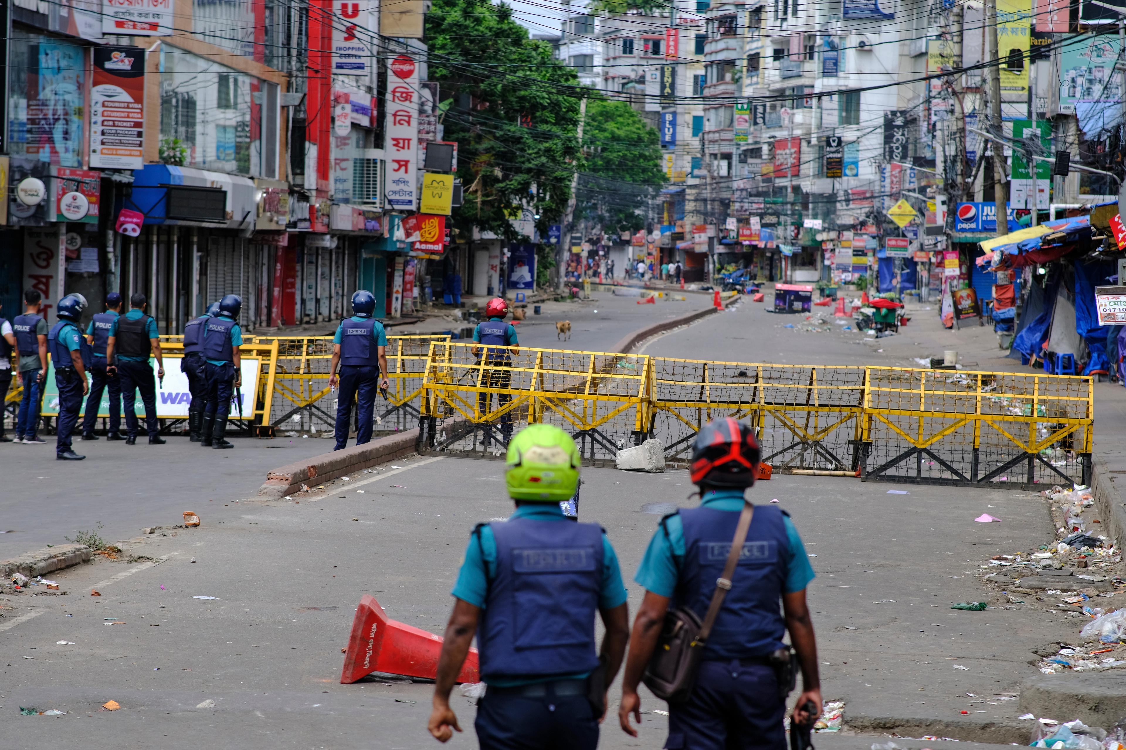 Poliser vid en avspärrning under utegångsförbudet i Bangladeshs huvudstad Dhaka under söndagen. Foto: Mahmud Hossain Opu/AP/TT