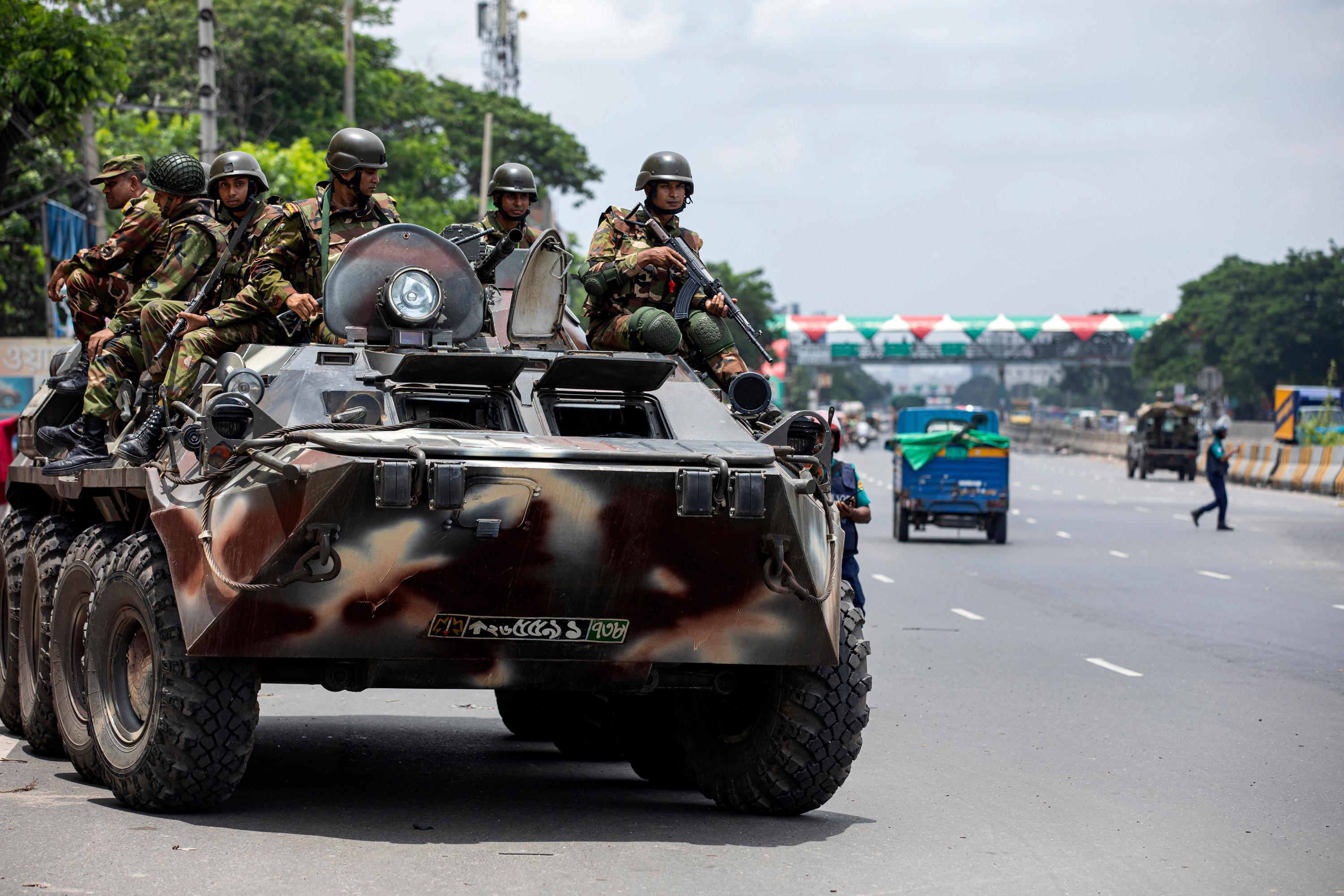 Militär patrullerar gatorna i huvudstaden Dhaka där utegångsförbud råder efter våldsamma studentprotester. Foto: Rajib Dhar/AP/TT